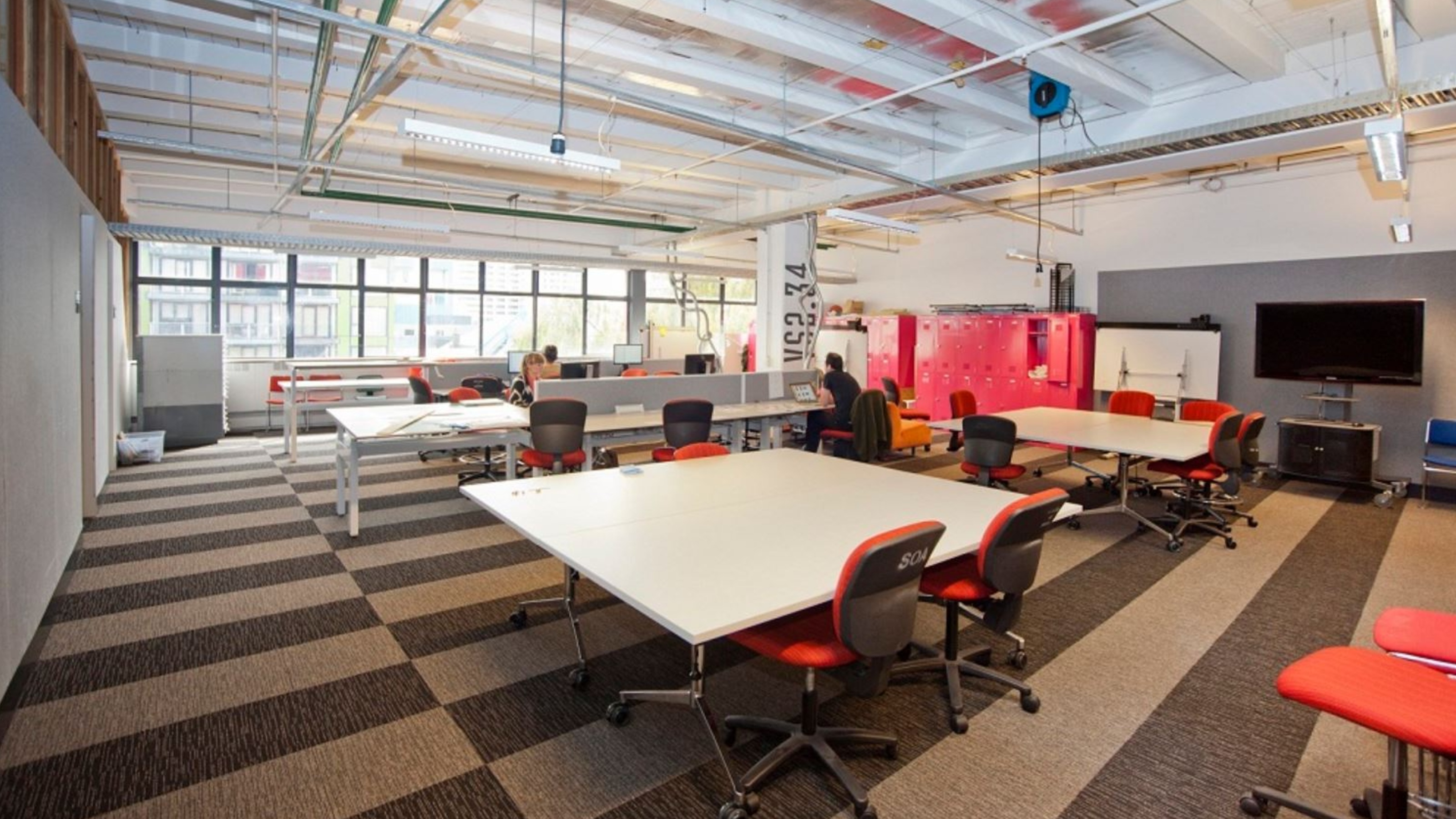 Wide angle view of unoccupied workroom with tables and computers