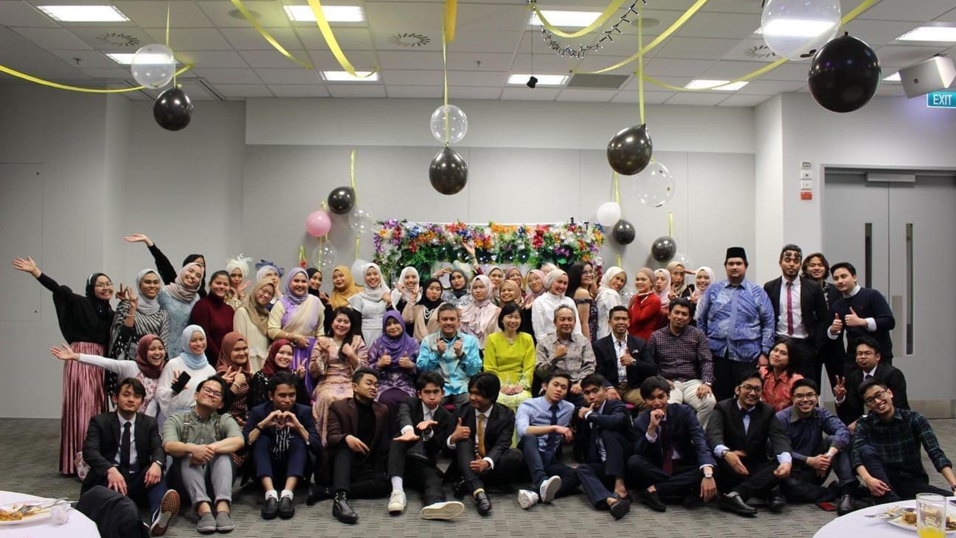 Group picture at Crazy Rich Asians event, with balloons hanging from ceiling.