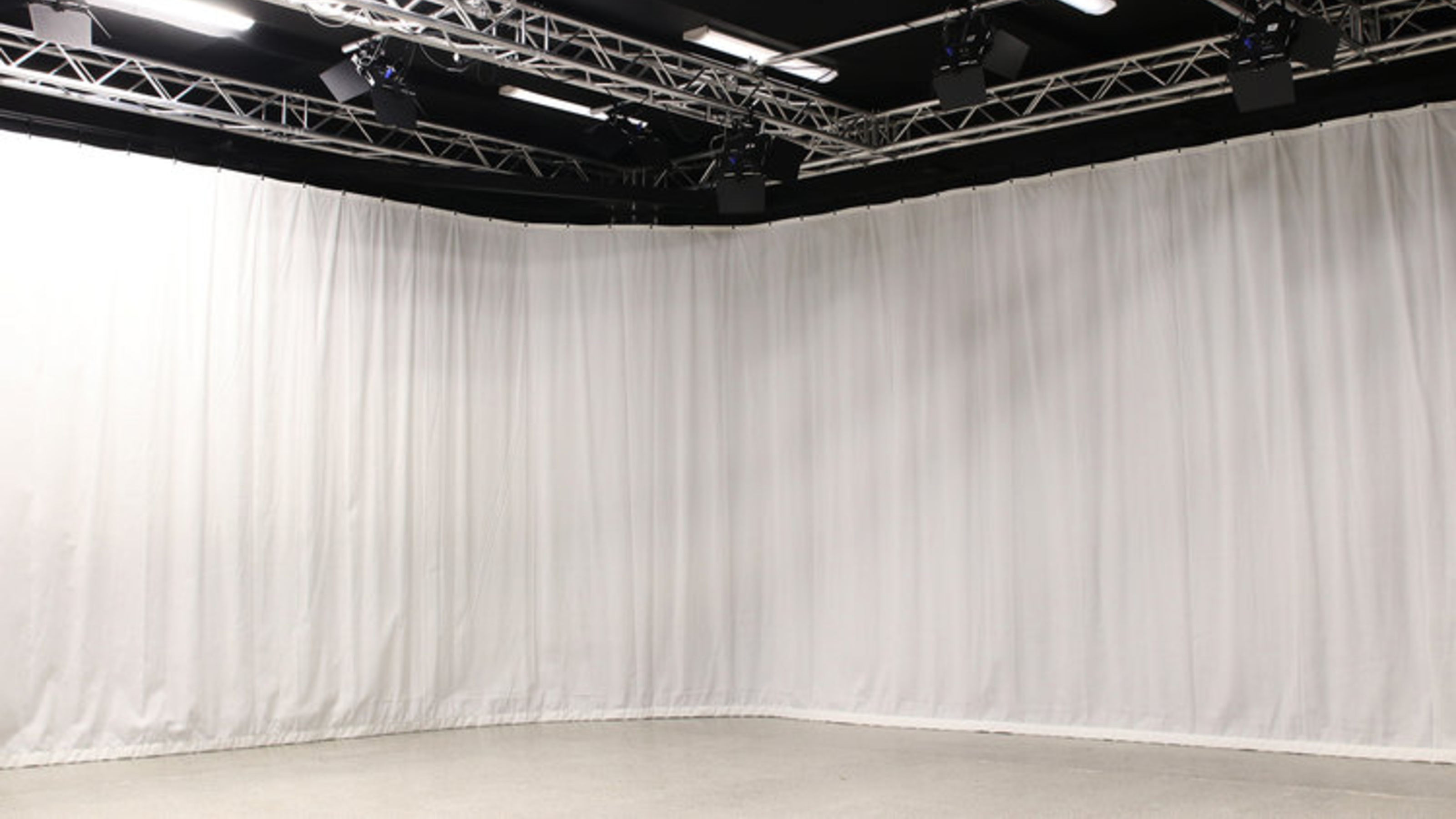 Film studio, view of white curtains and lightning grid.