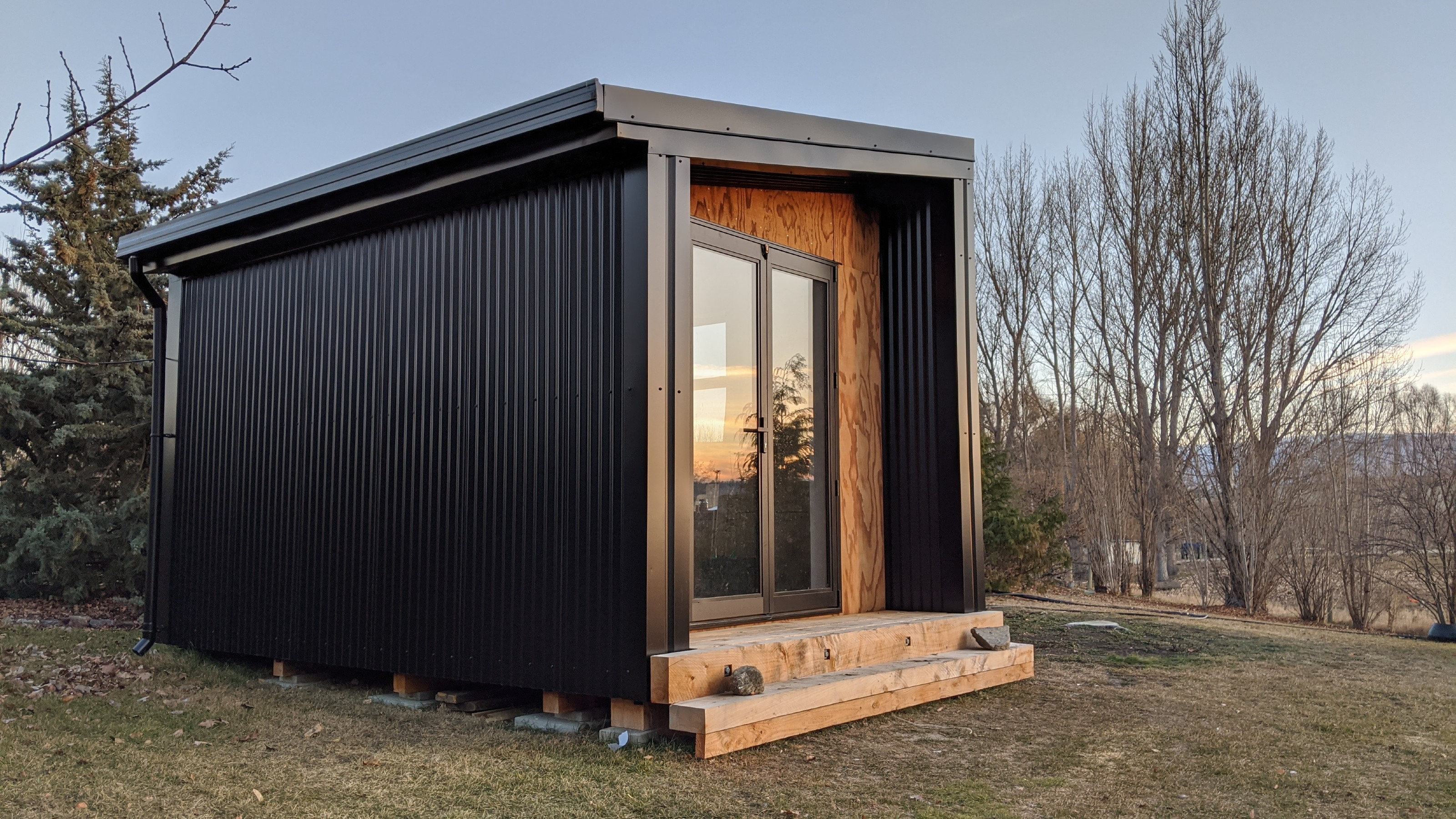 Wooden batch cladded in black metal built using X frame