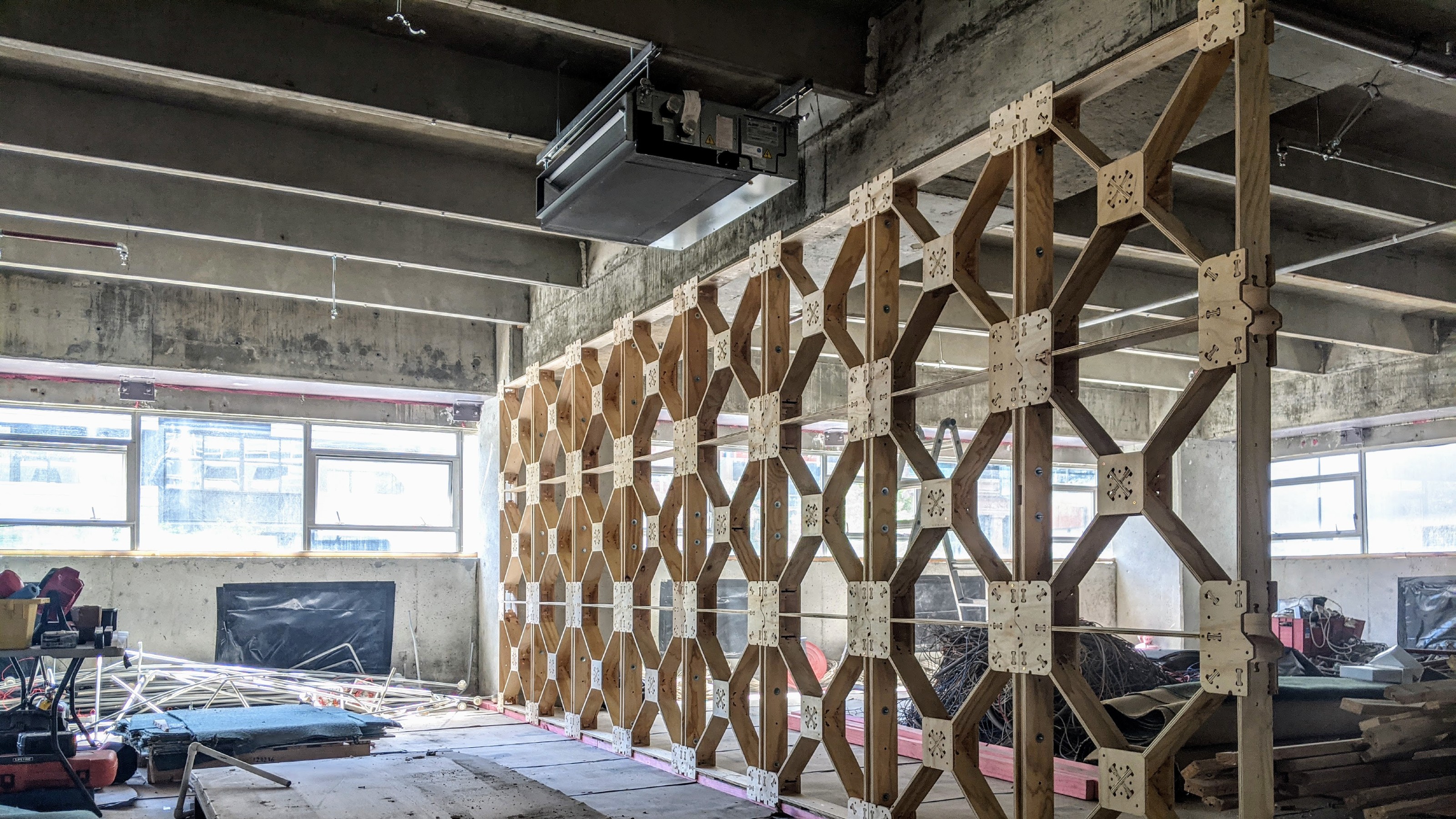 Diving wall being constructed in industrial space using wooden X frame