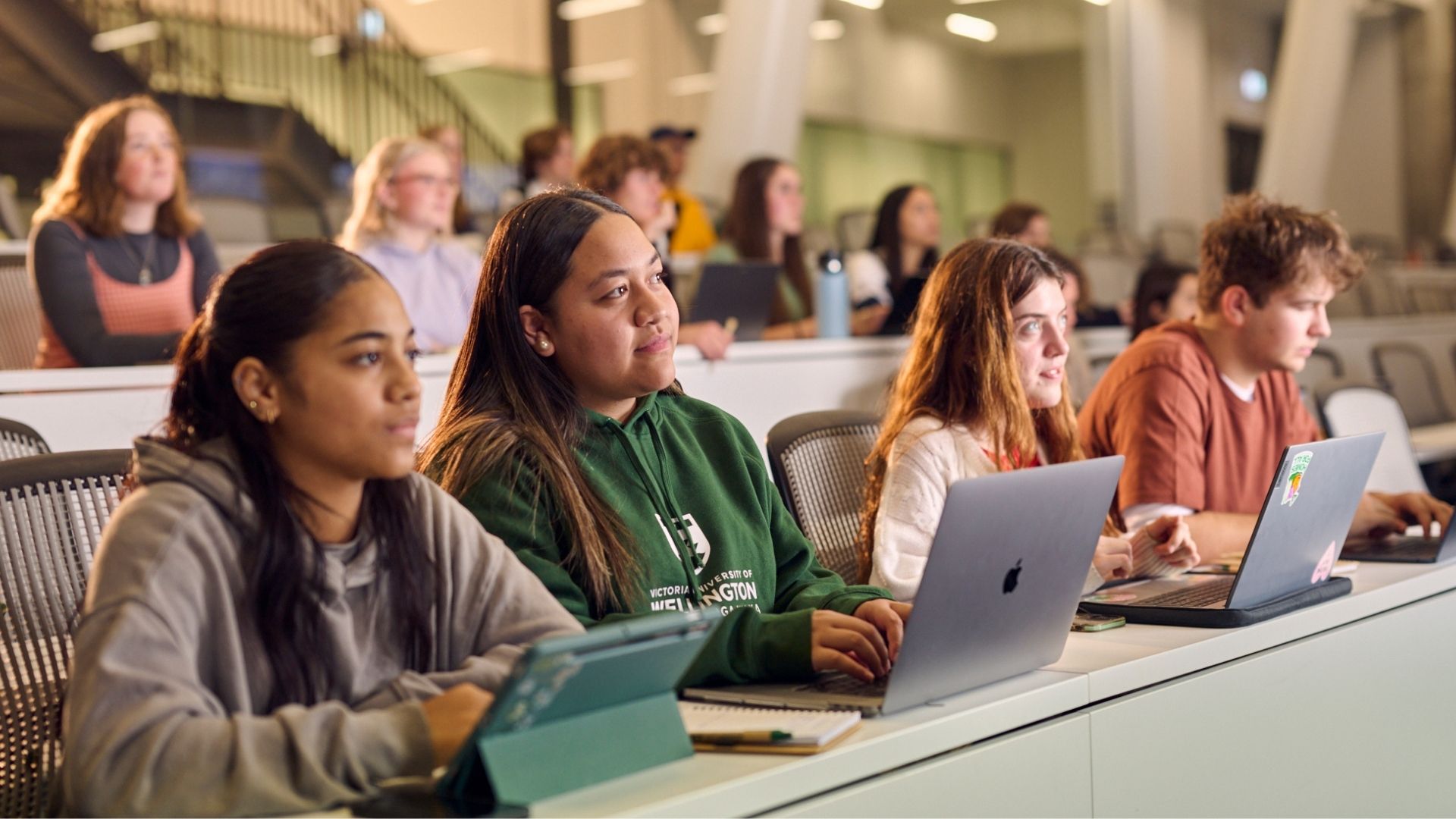 Students sitting in a lecture room and using their laptops