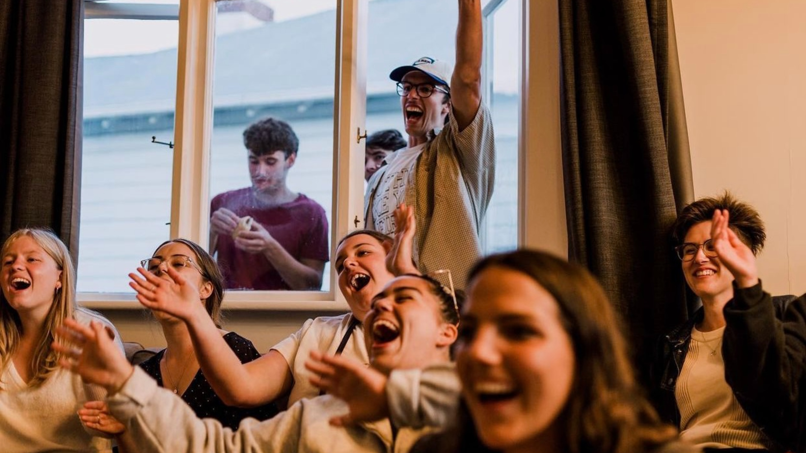 Students singing, smiling, and clapping hands during church event.