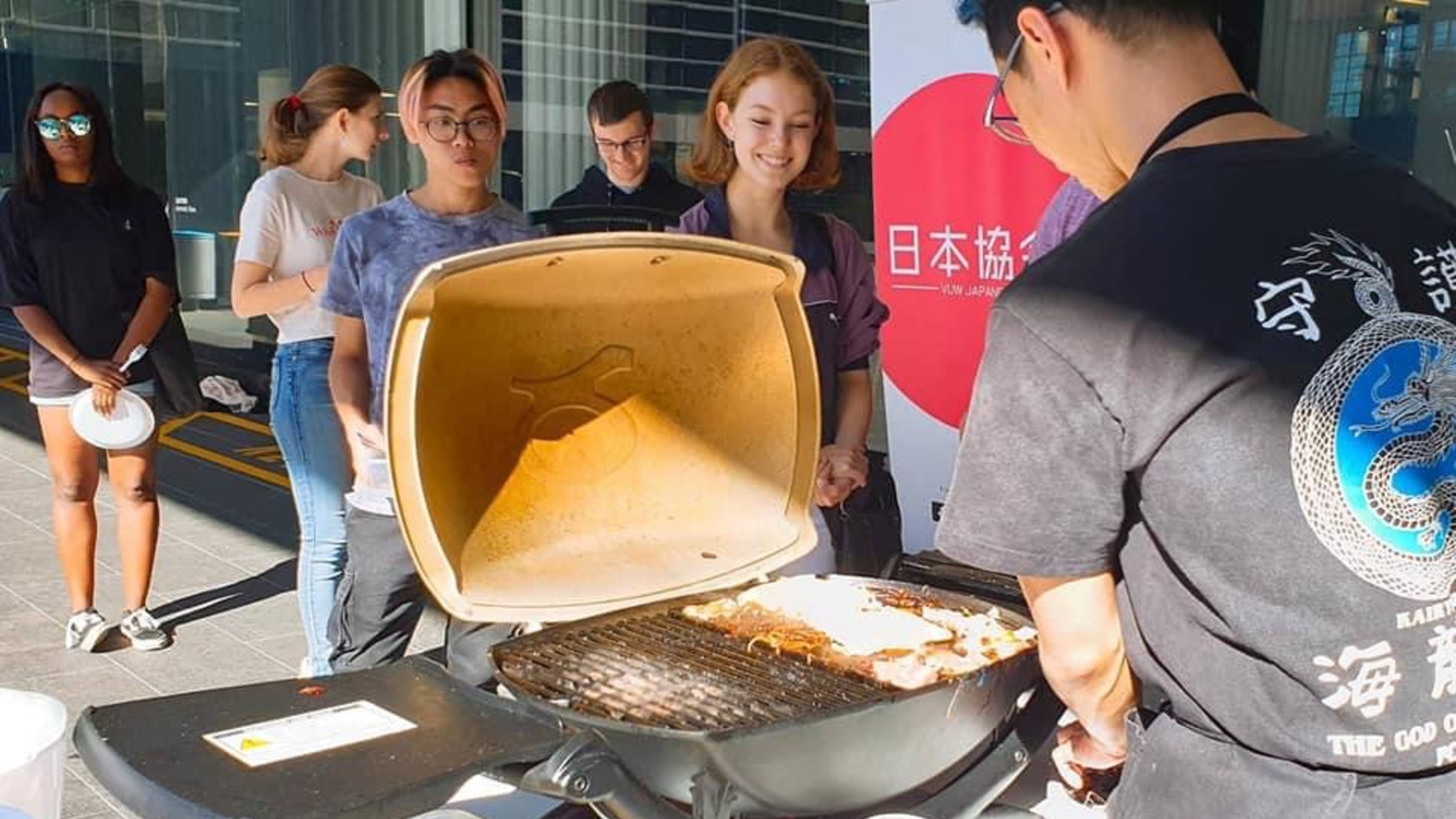 Students lining up at BBQ stand in the Hub courtyard for fundraiser.