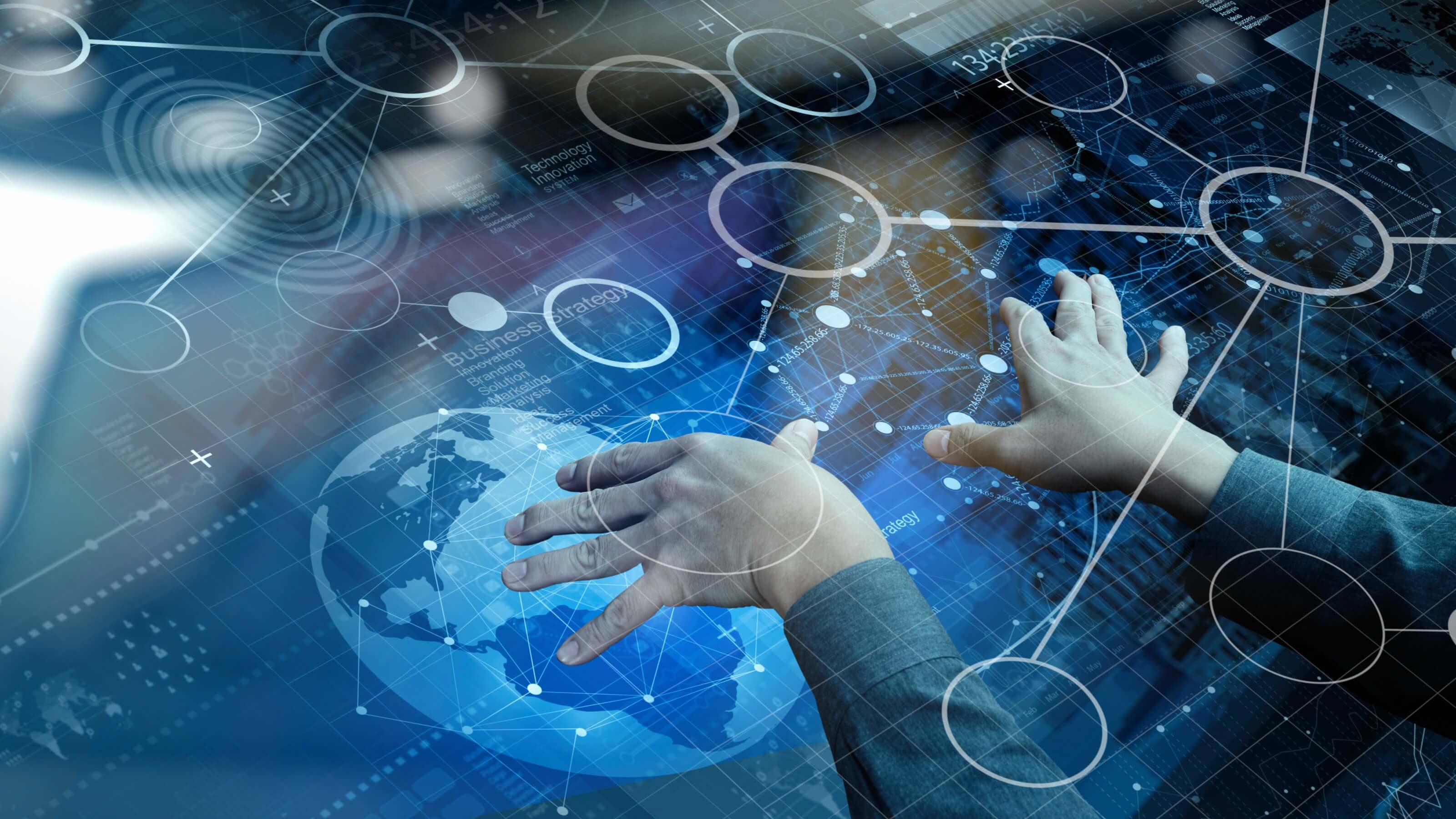 A large touch screen with a globe and two hands working with the images.
