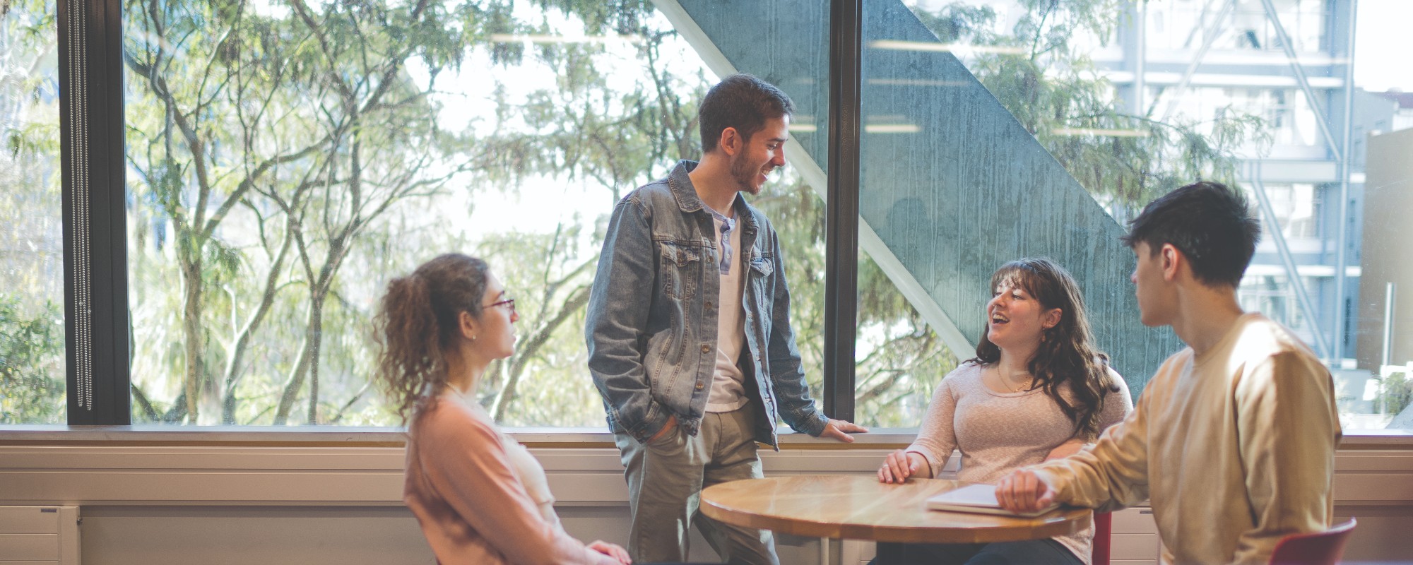 A group of students talking around a table at Te Aro campus.
