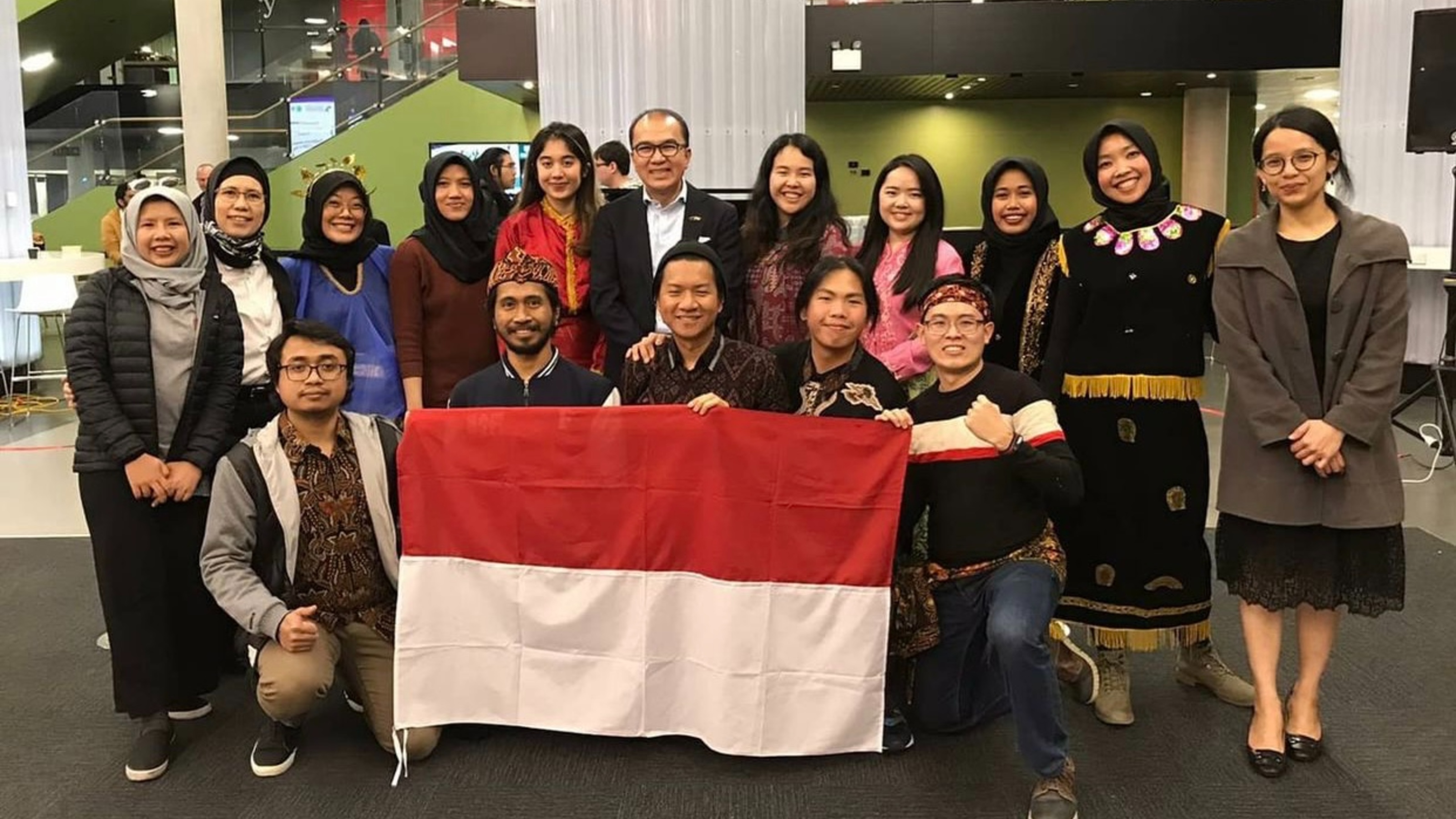 Group picture of Indonesian Student Association members, holding white and red Indonesia flag.
