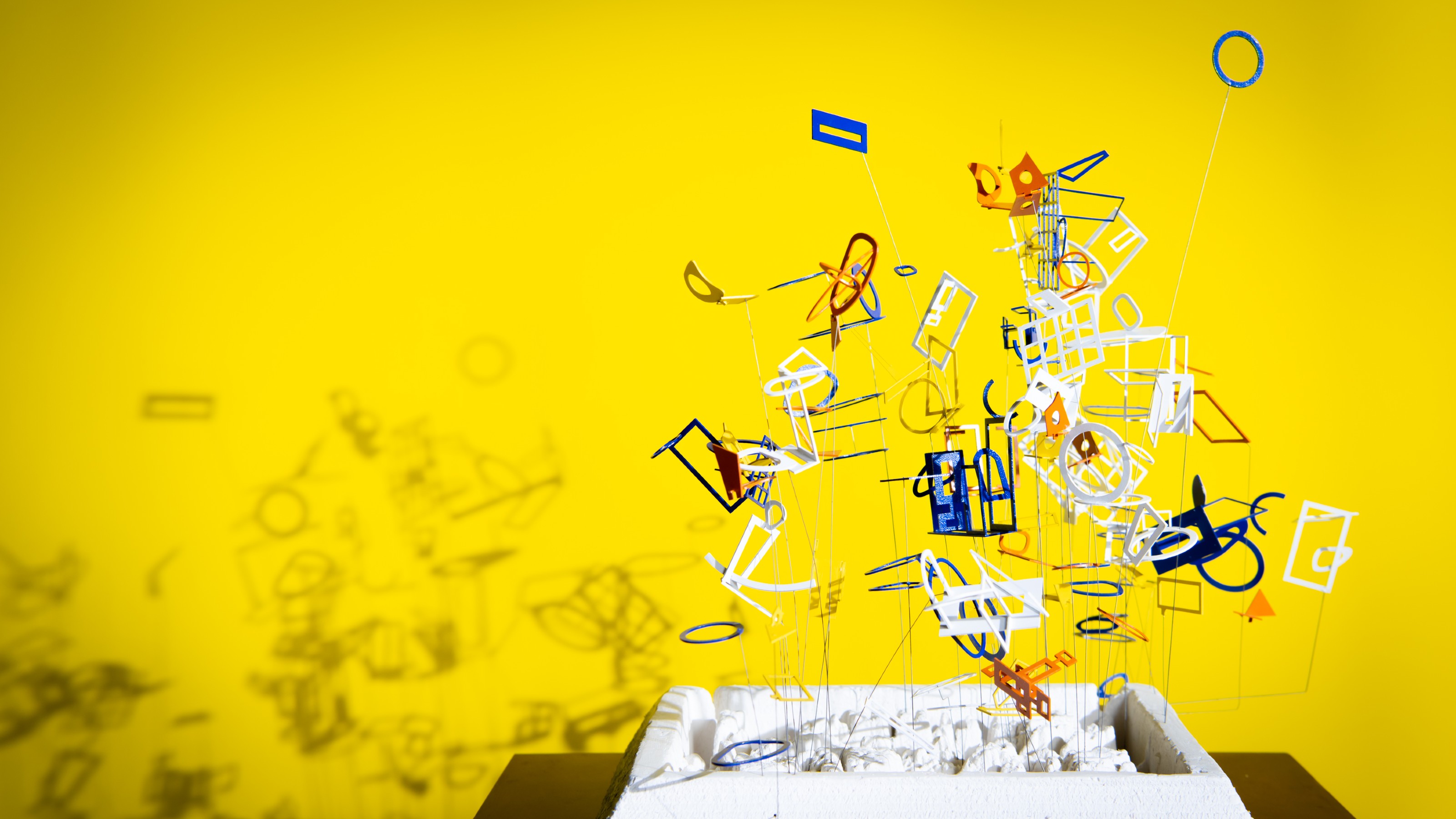 blue, red, orange and white model in front of yellow background