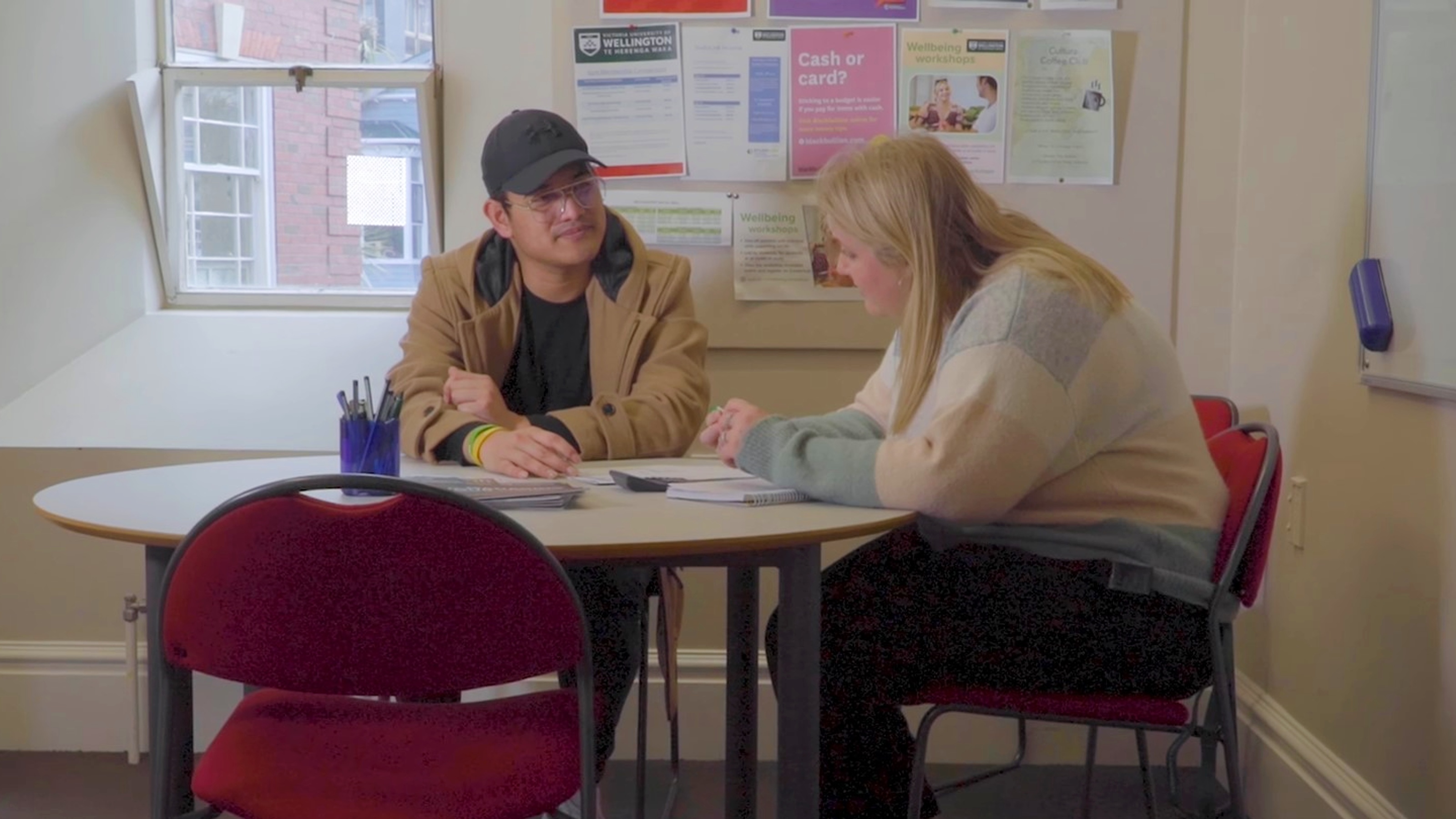 Two smiling people facing each other across a table