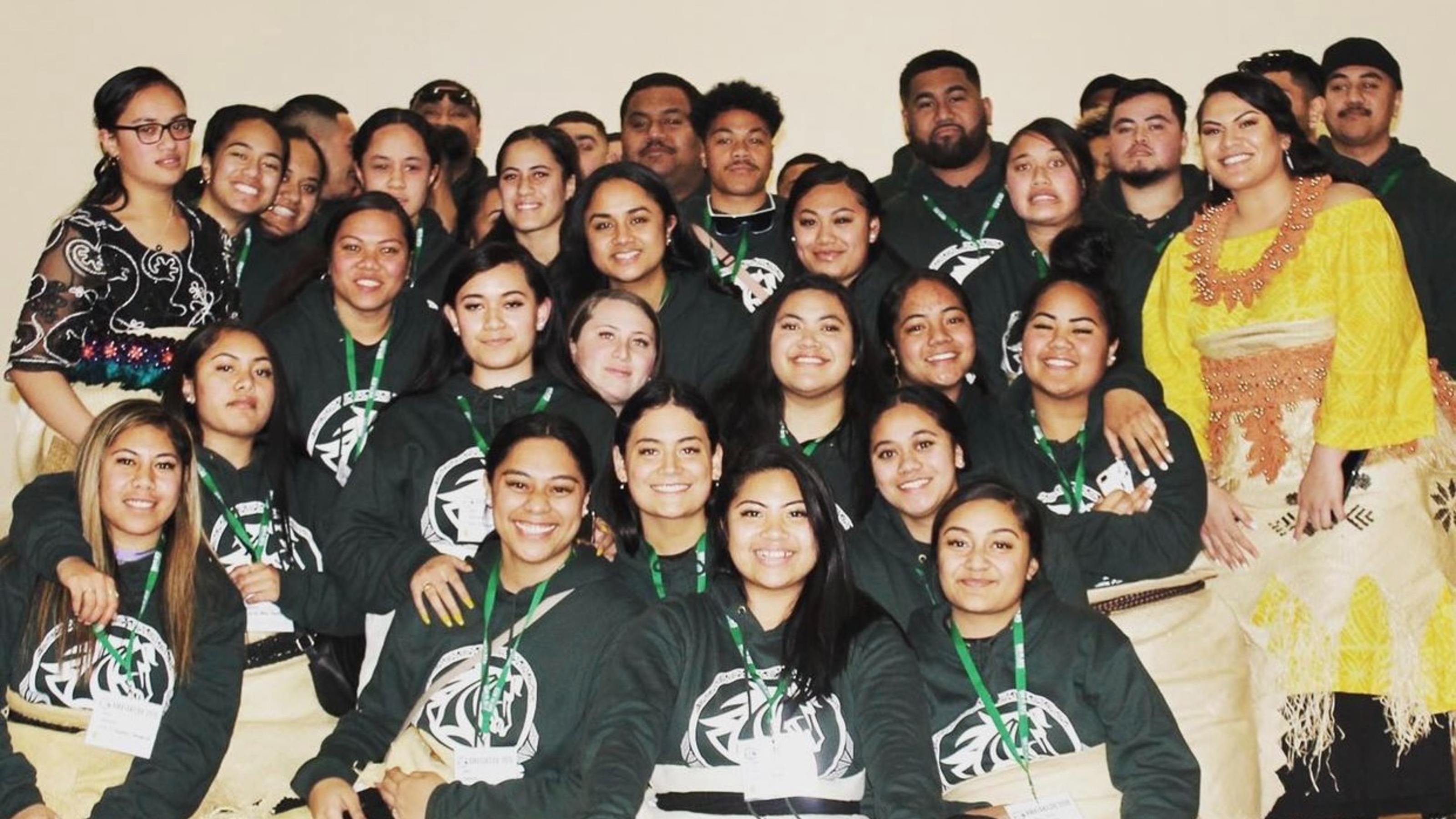 Group picture of students wearing their association hoodies after a performance.