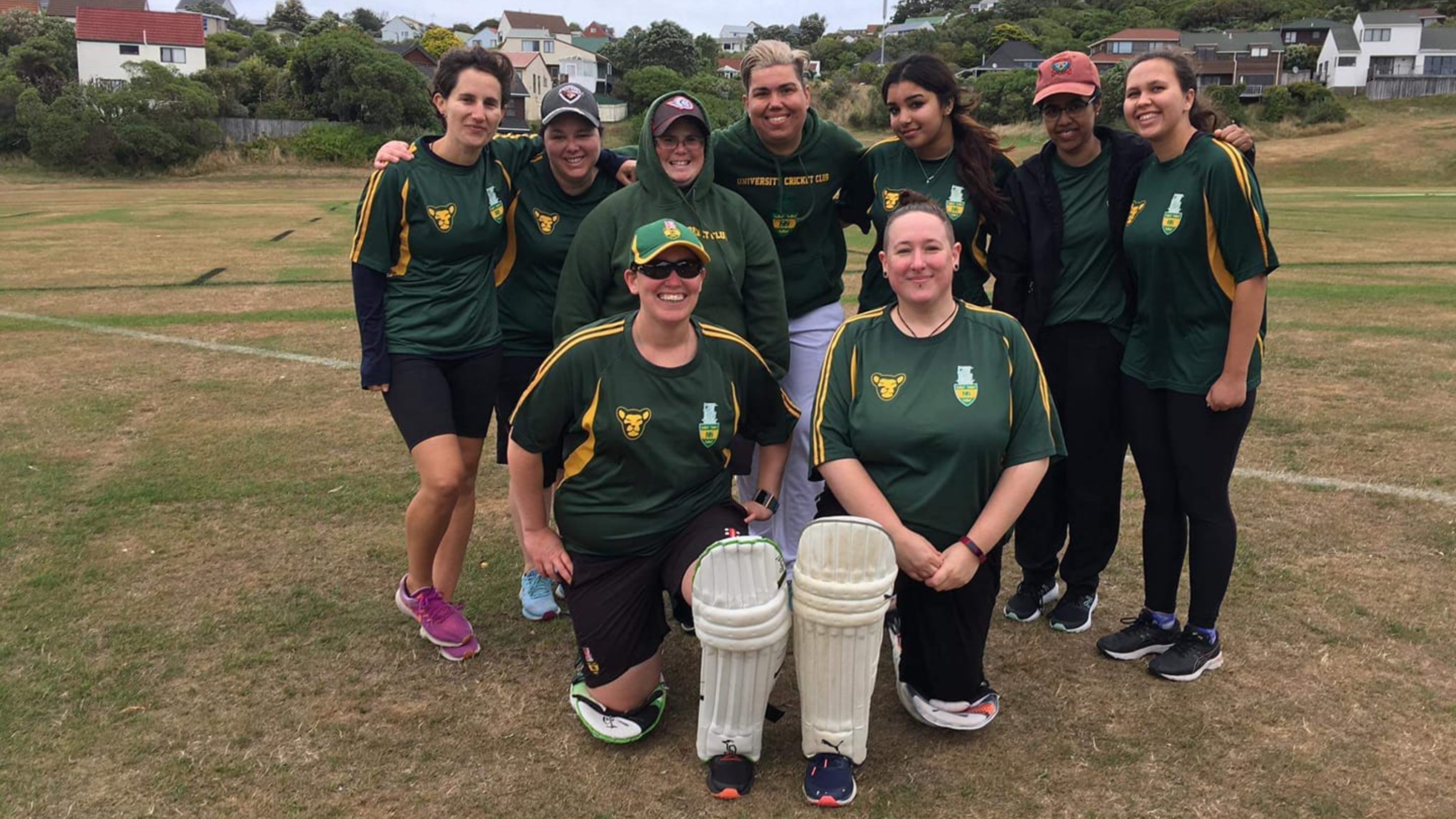 Group picture of the cricket team, wearing their green and yellow jerseys.