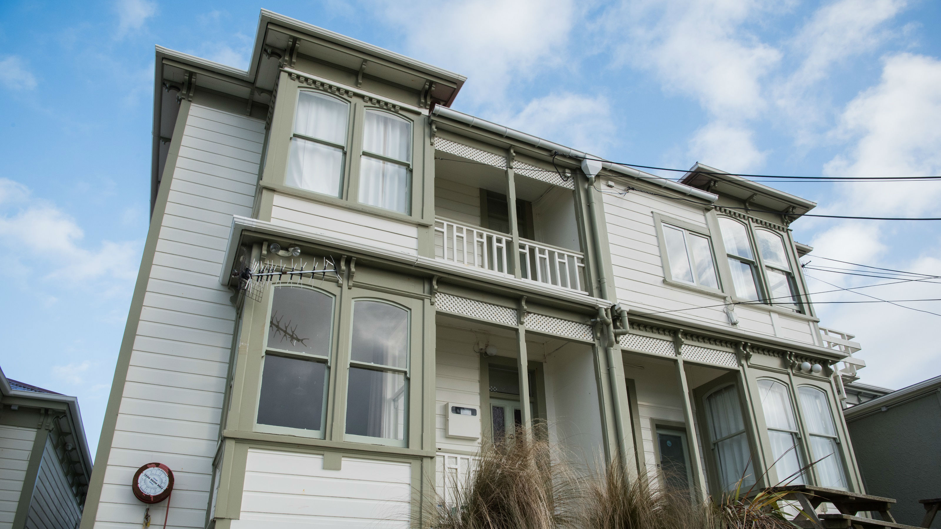 Uni Hall Whanau building exterior. Two story residential building with green trim.