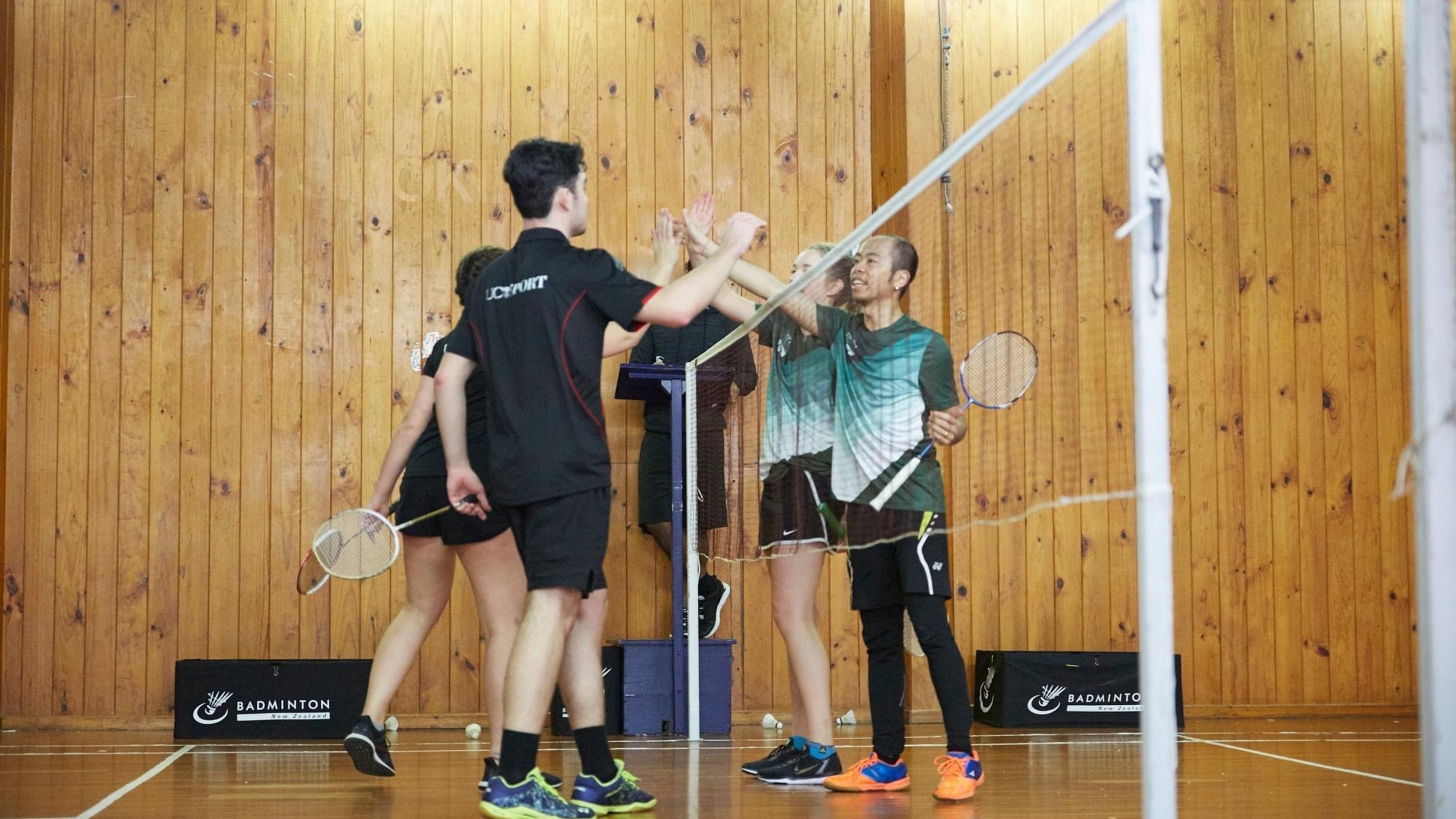 Players high fiving their opponents over the net.