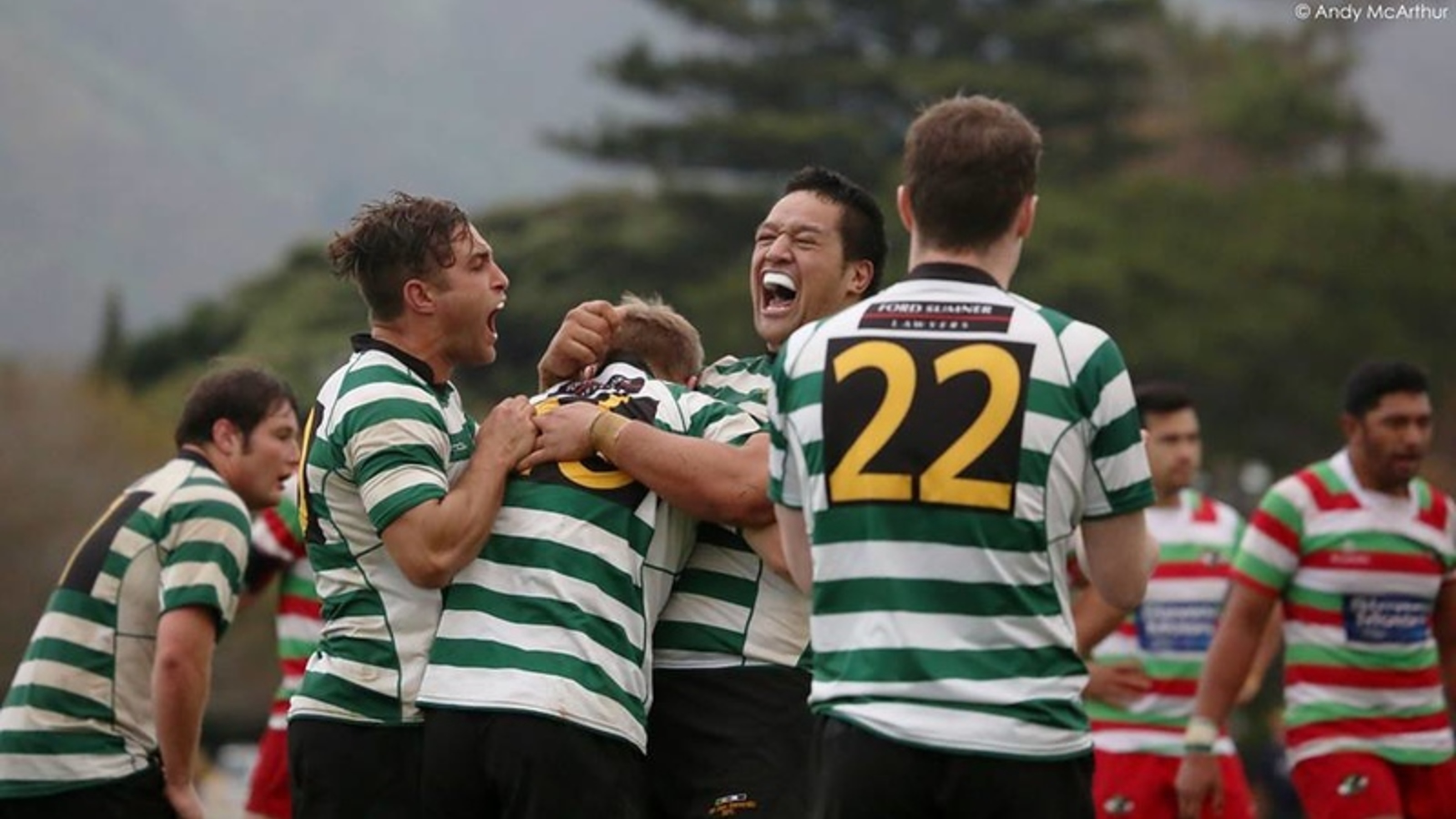 Happy rugby players hugging after winning a game.