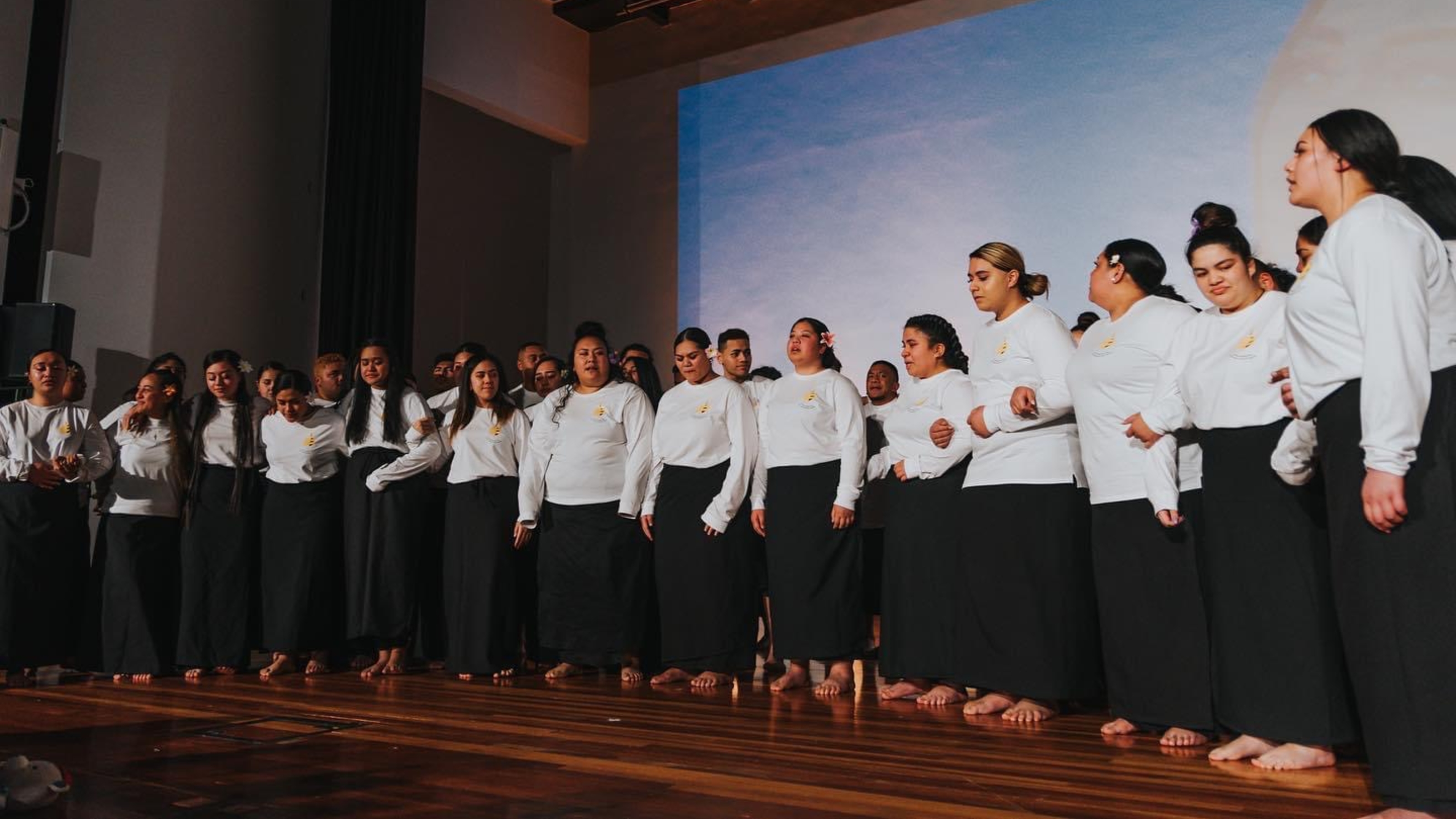 VUSSA members, all wearing black and white, on stage during prayer night.