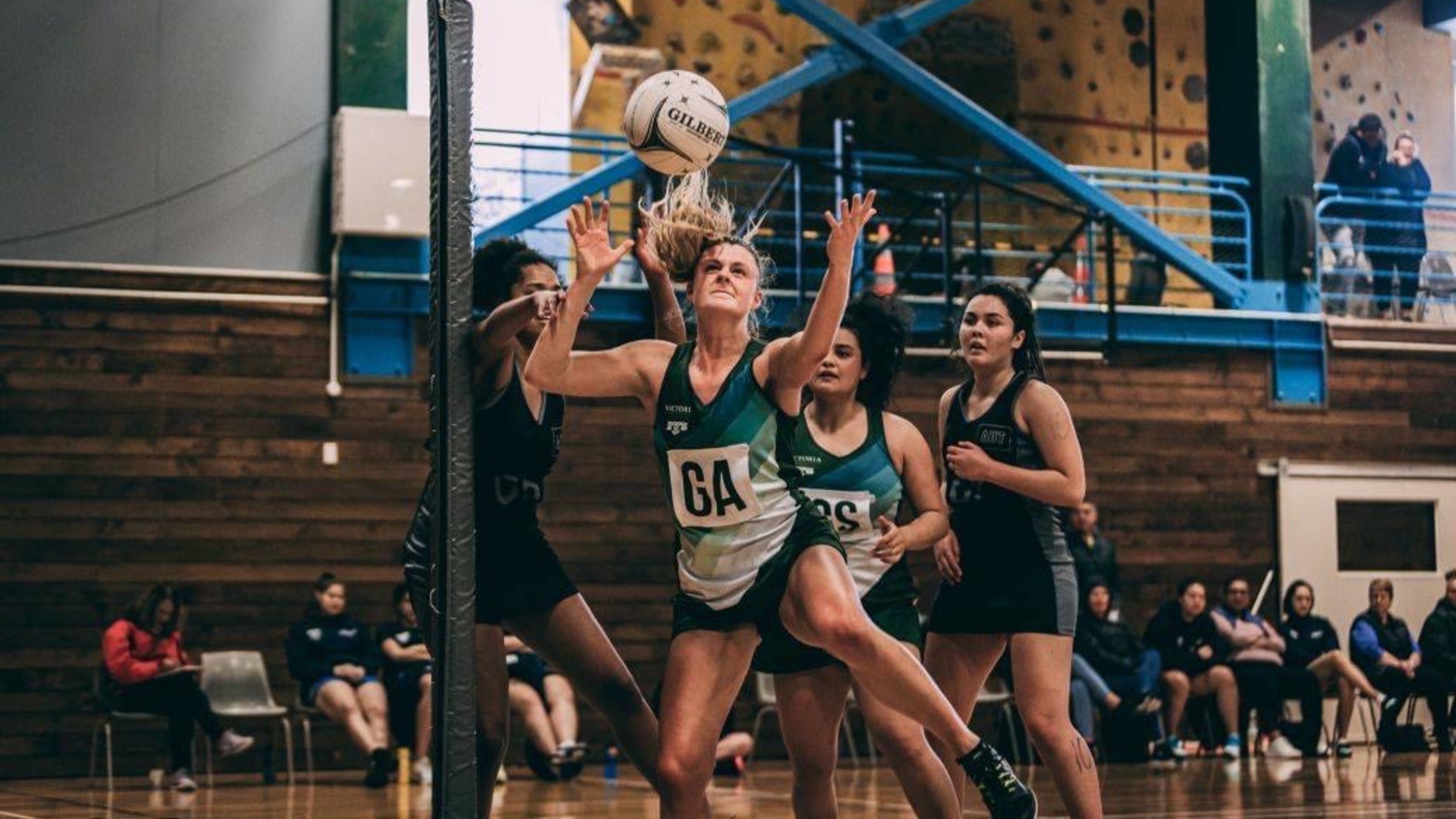 Player mid-action, arms out and jumping to reach ball.