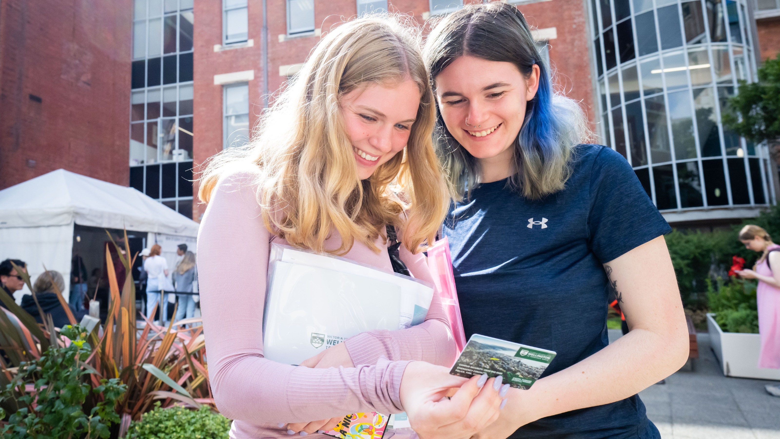 Two new students looking at an ID card