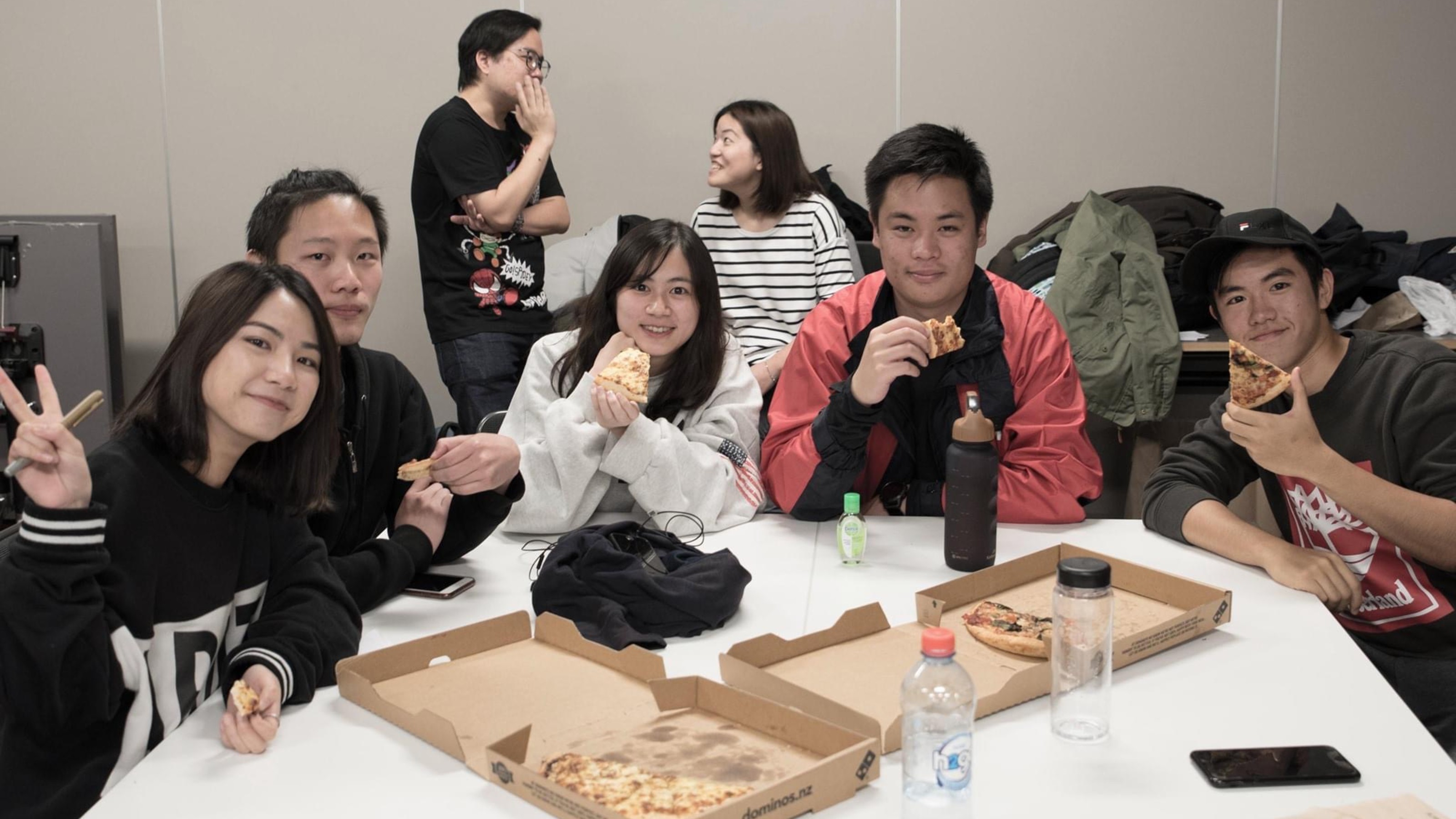 Student sharing pizza in classroom.