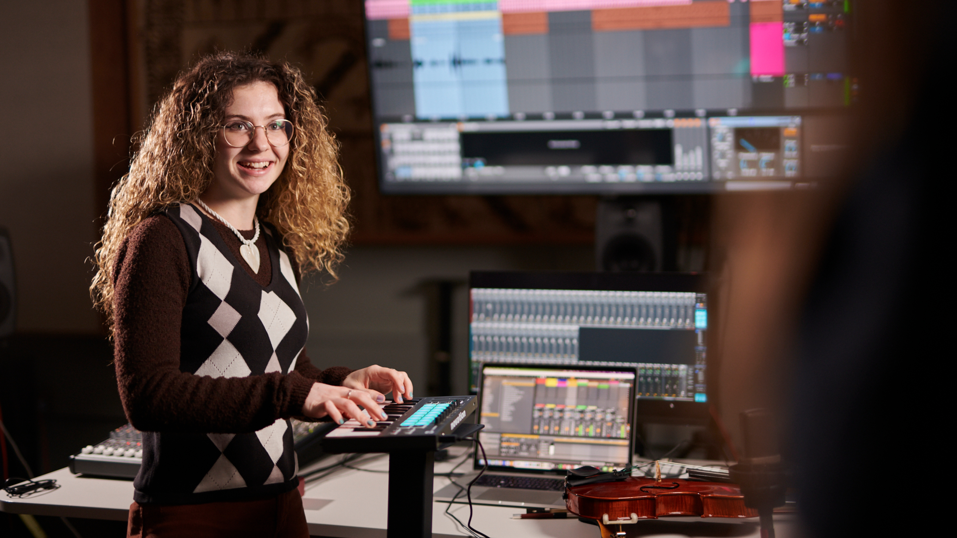 A music student works with a keyboard and computer equipment