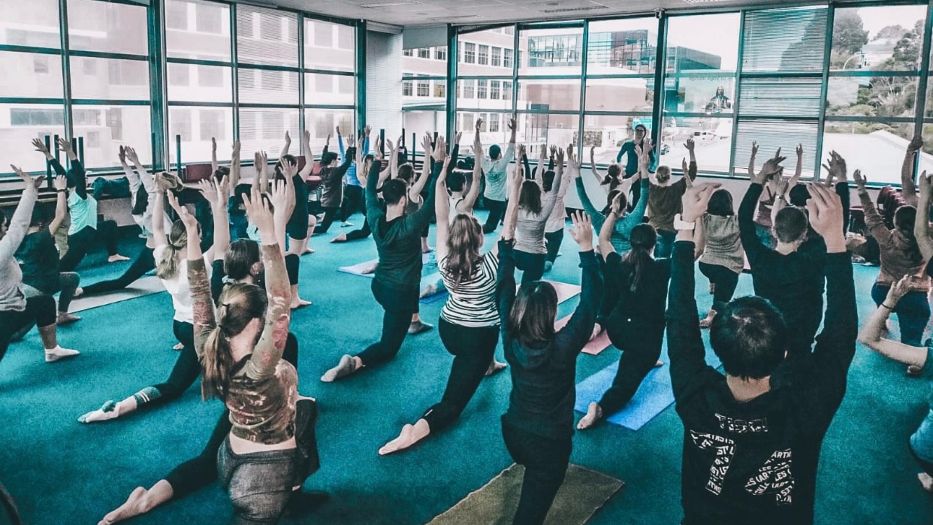 Yoga session with all students arms in the air.