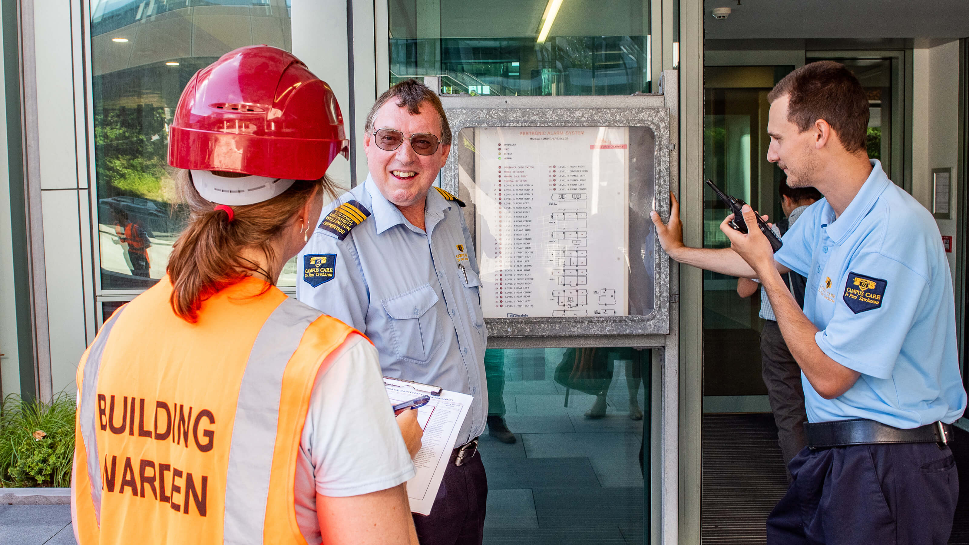Building warden talking to two Campus Care officers.