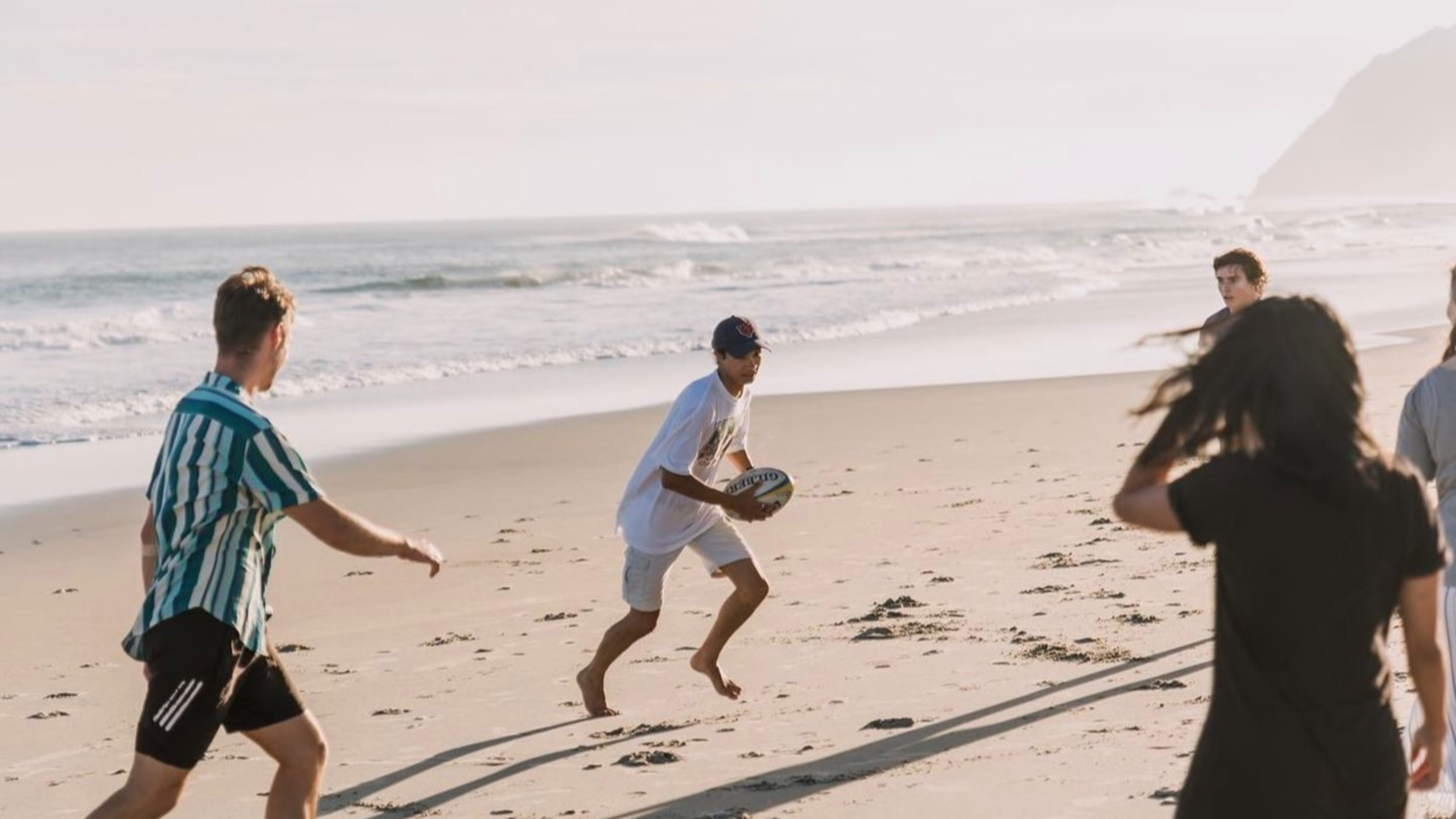 Members playing rugby on the beach.