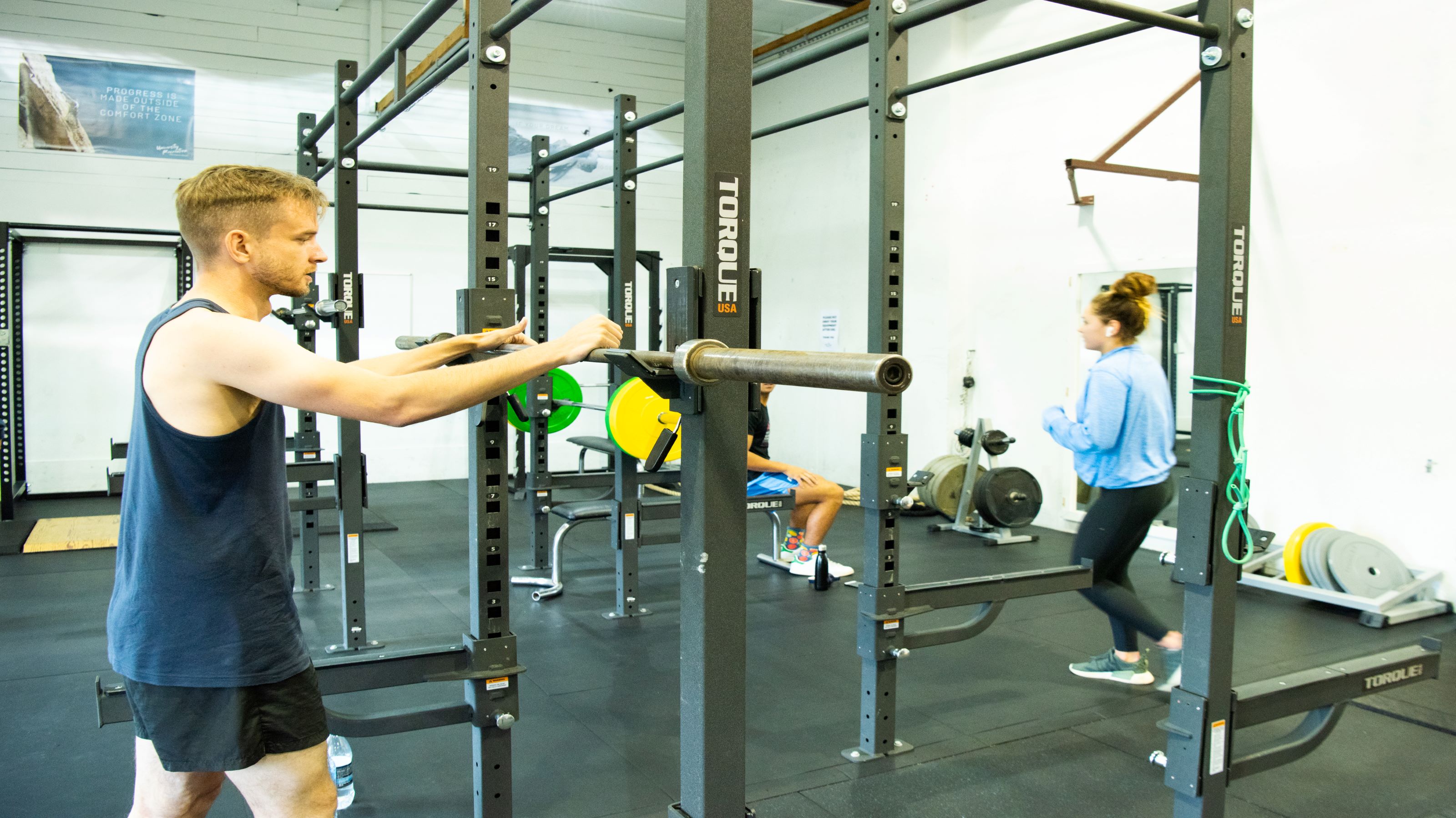 Male student lifting weights in front of mirror