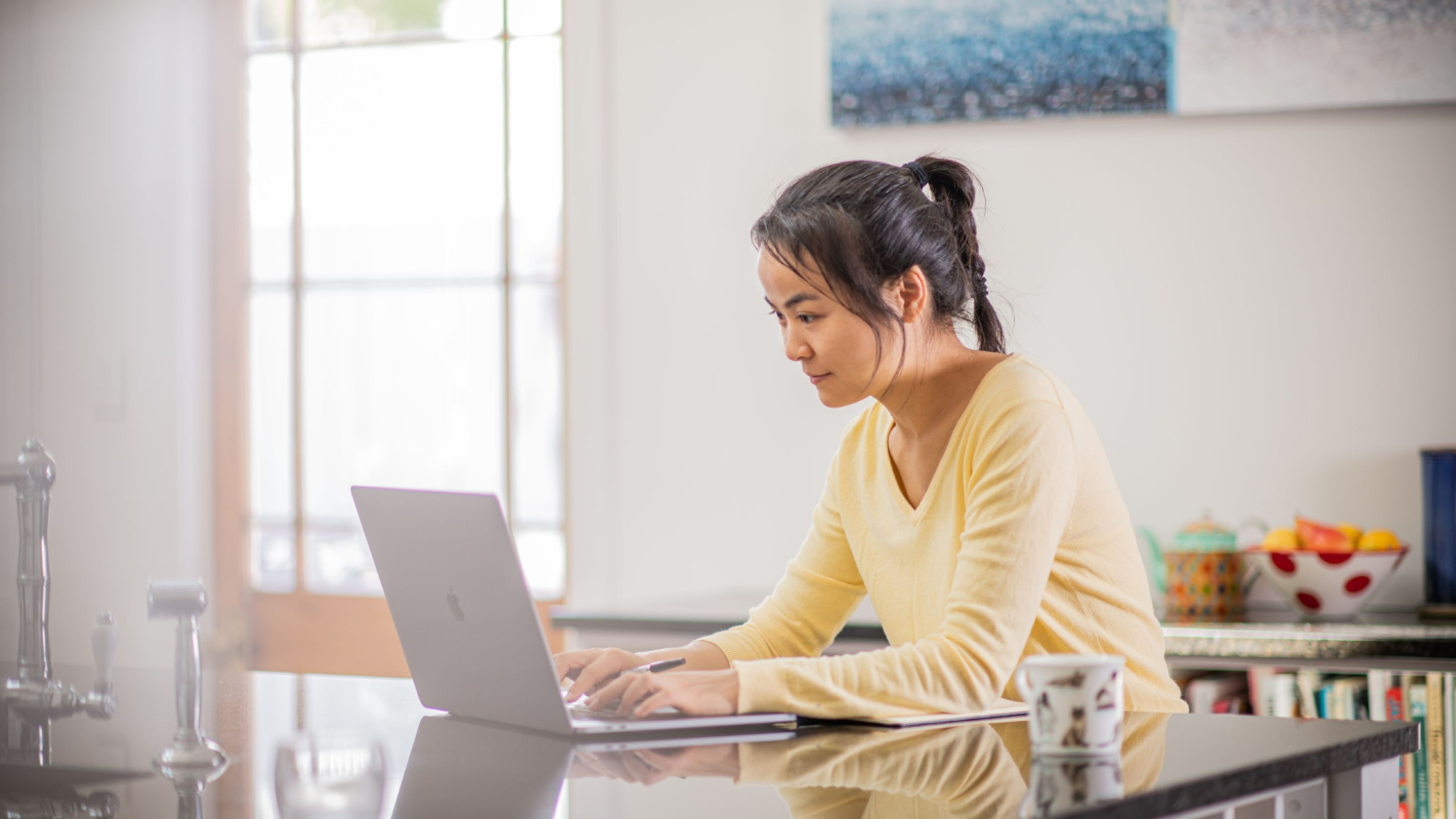 A woman on a table typing away on her laptop
