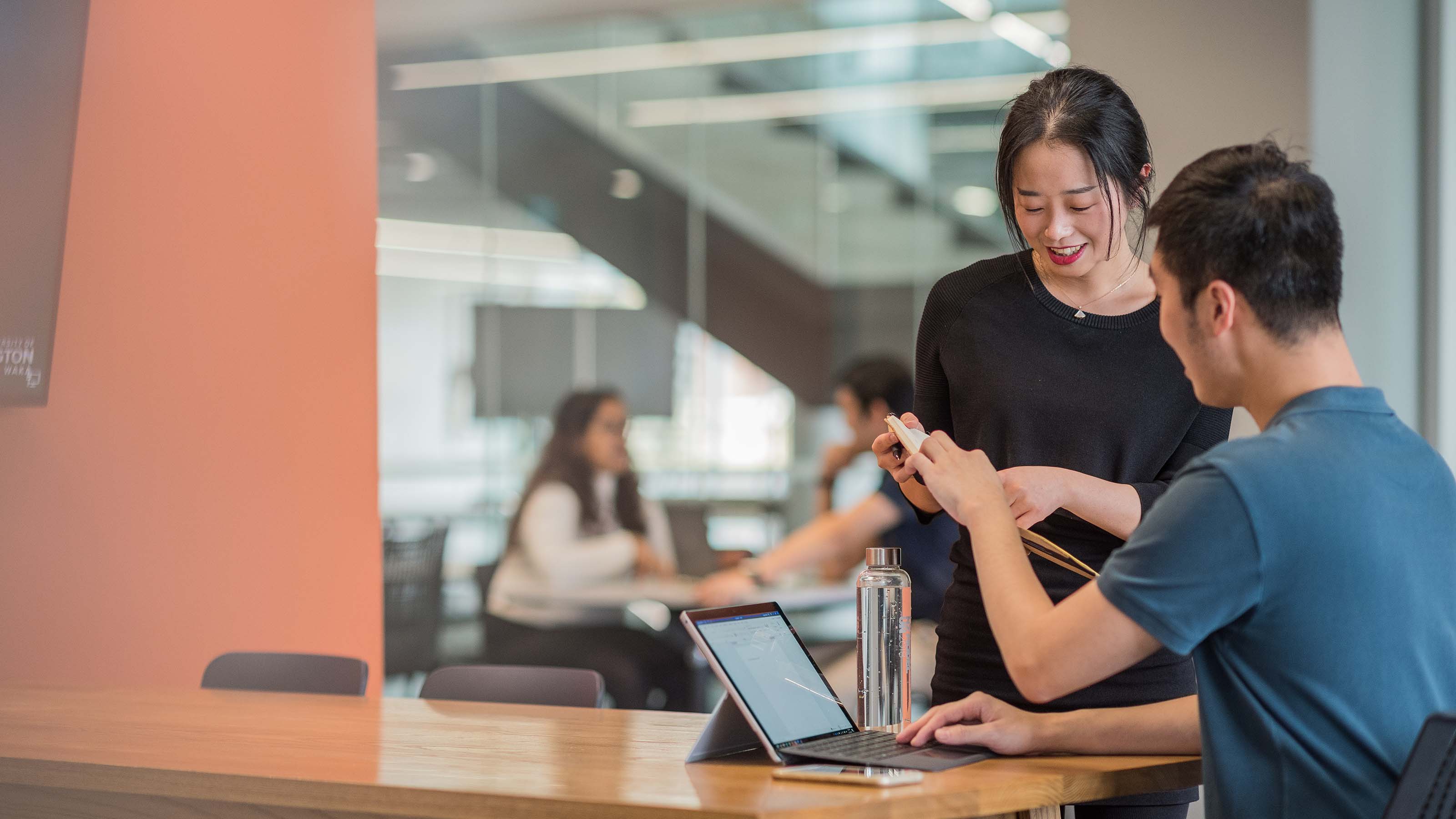 Two students consulting each other on their work