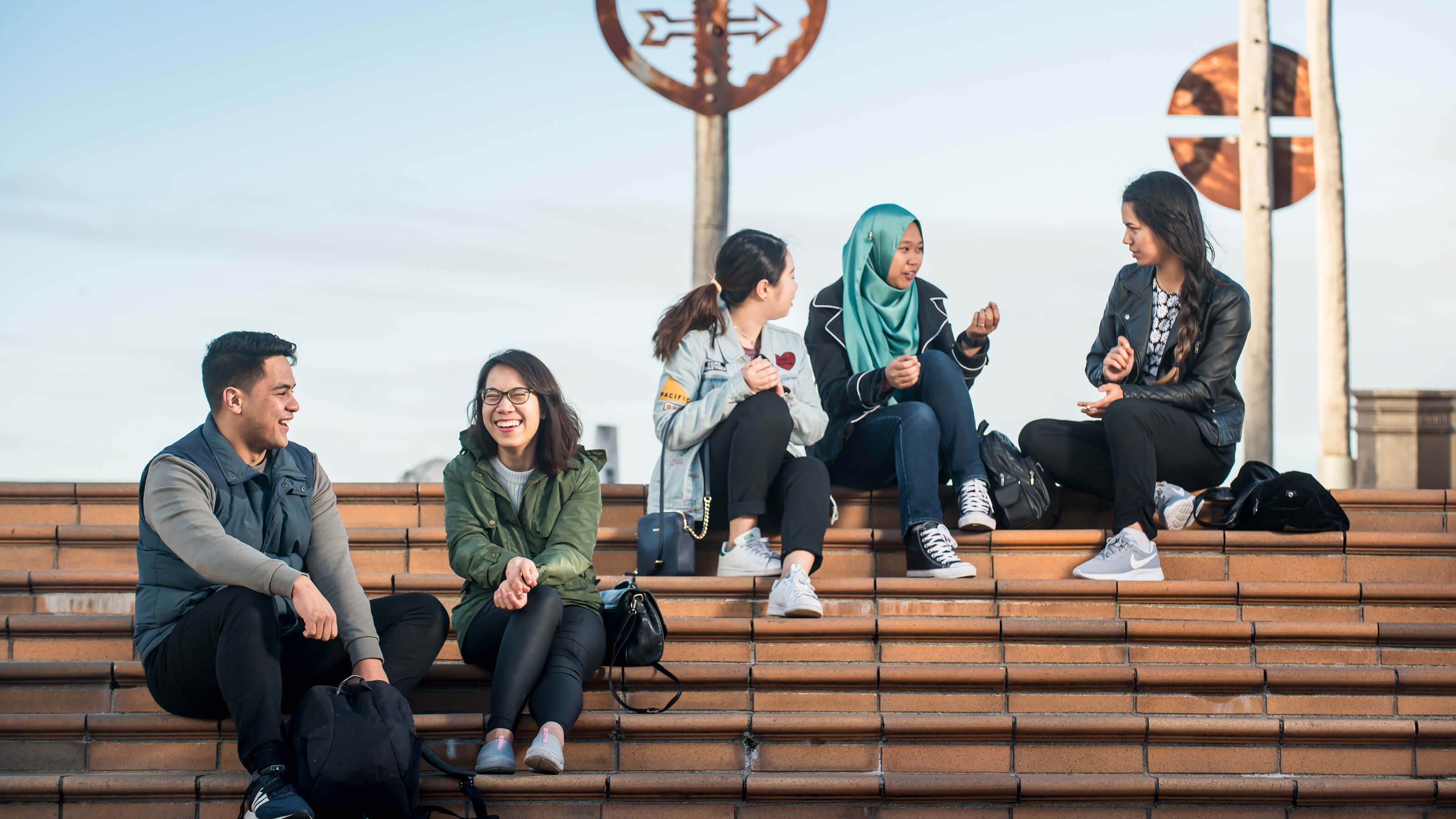 Students sitting on stairs in Wellington city centre chatting.