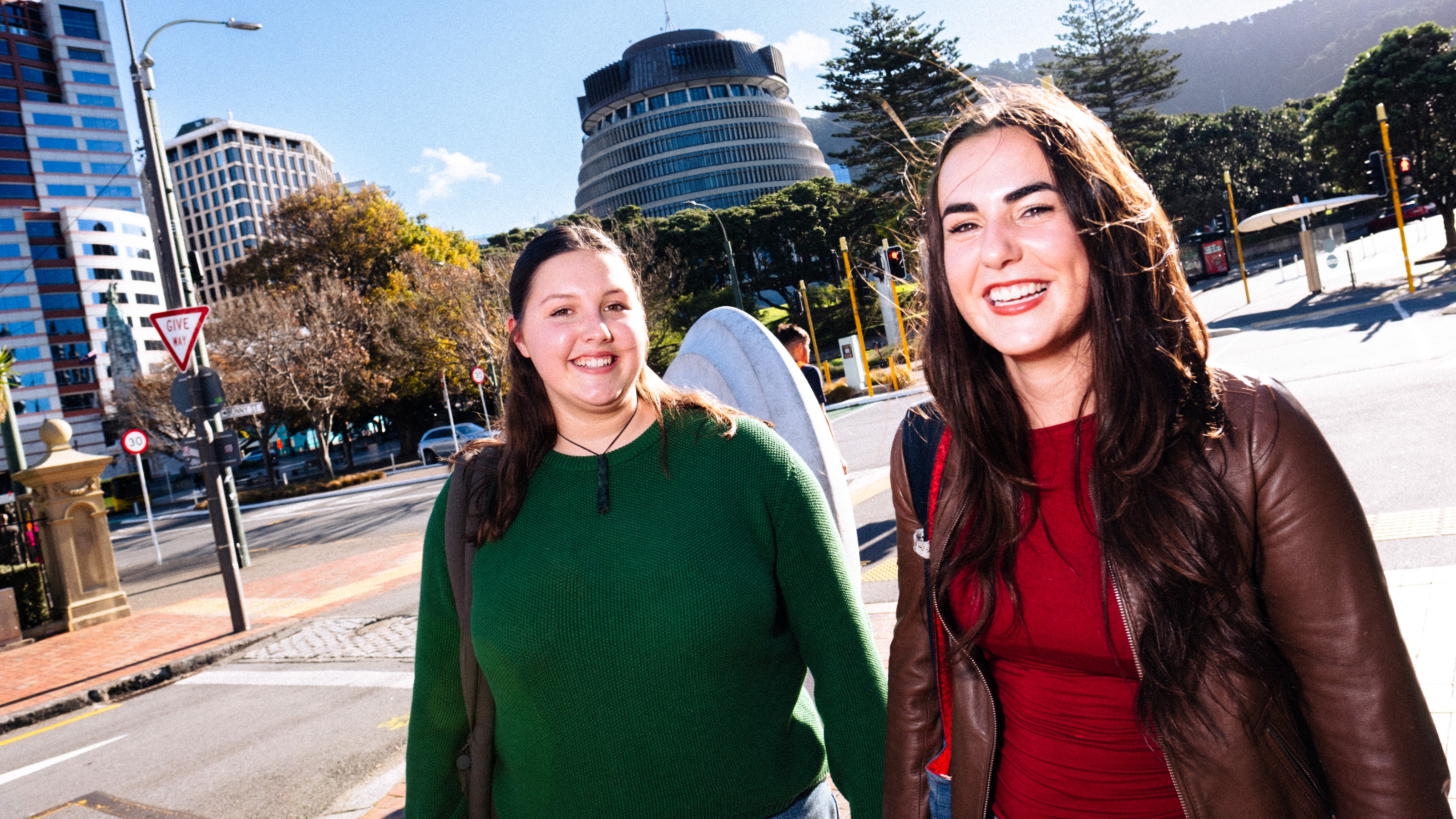 Two students walking and smiling in front of the Beehive