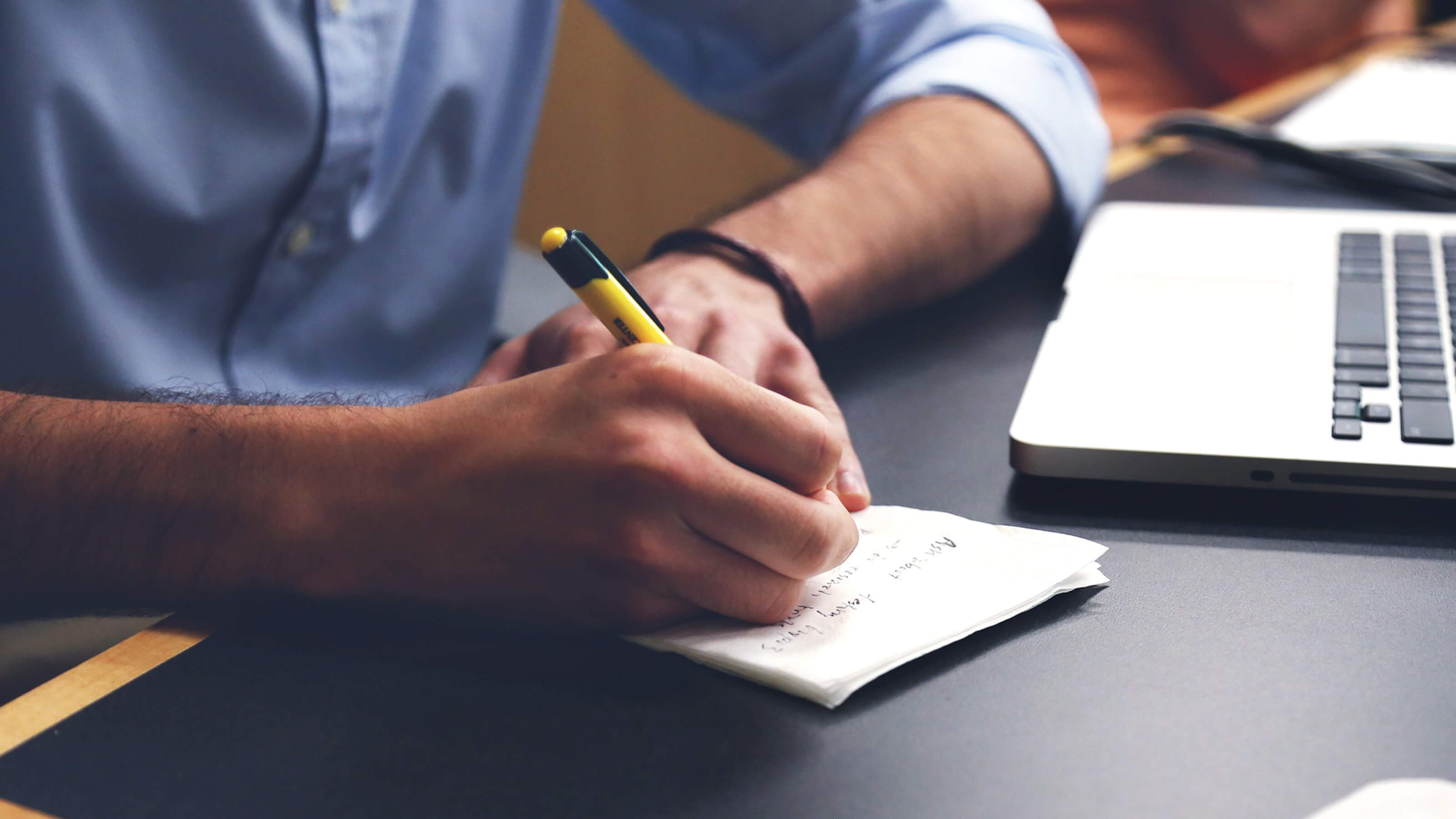 Man jots down notes on a napkin.