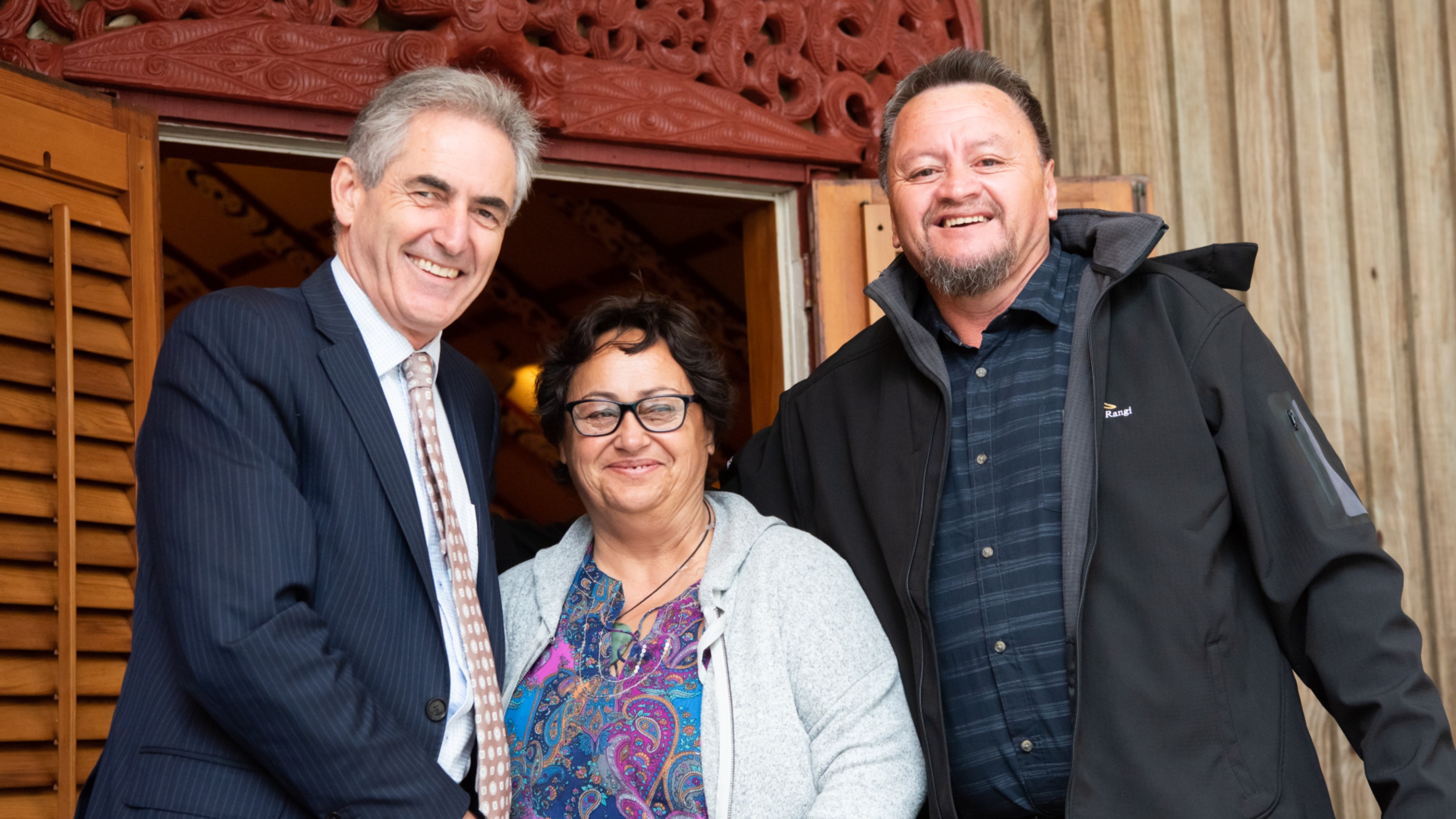 Vice-Chancellor and two other people outside Te Herenga Waka marae.