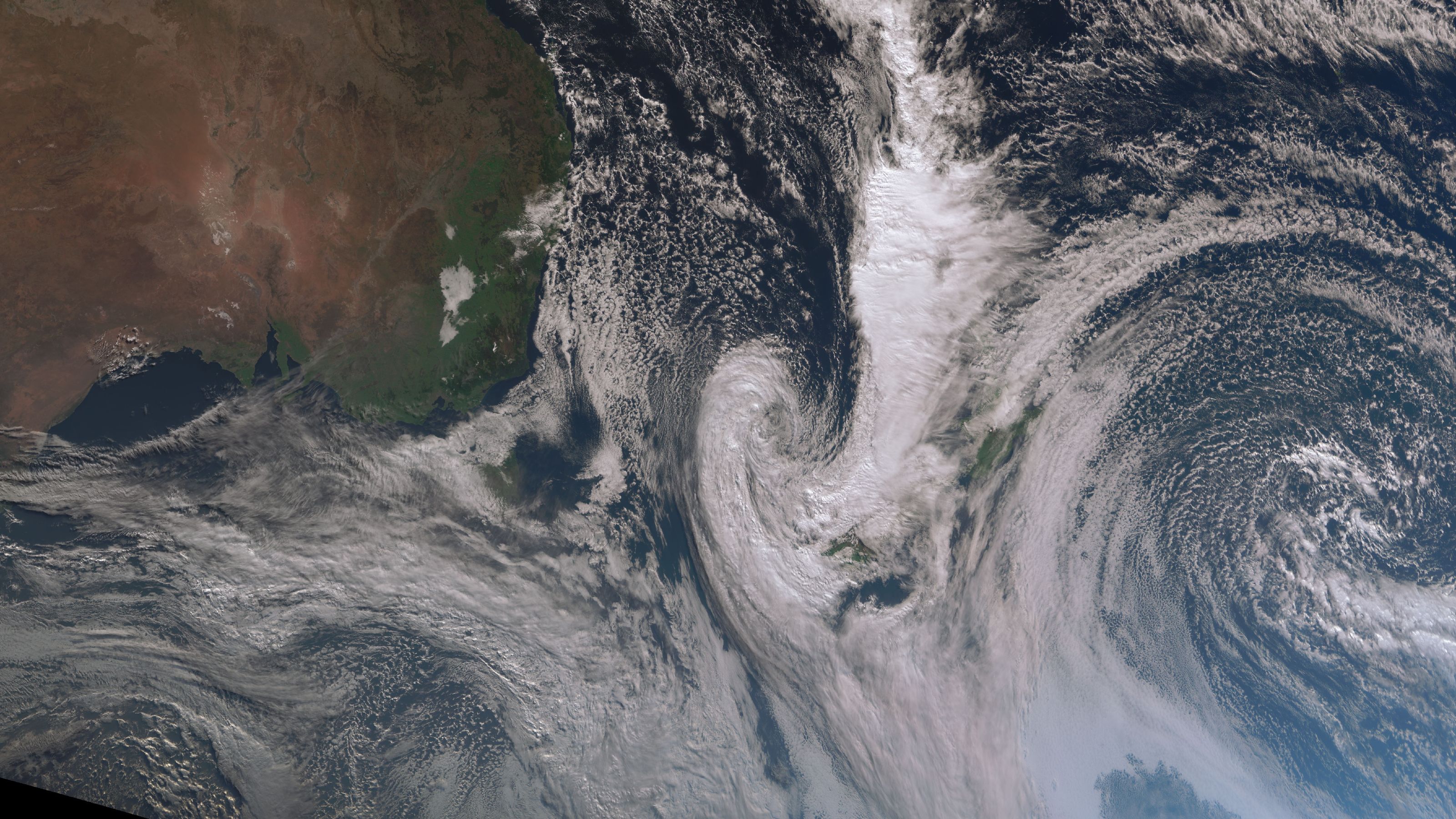 Satellite image of swirling white weather system over New Zealand