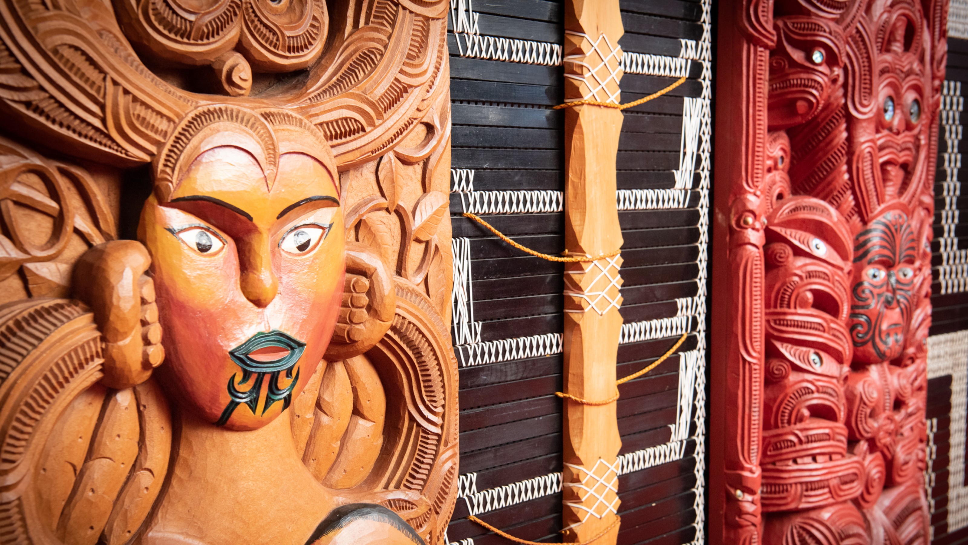 Two Māori wooden face carvings.