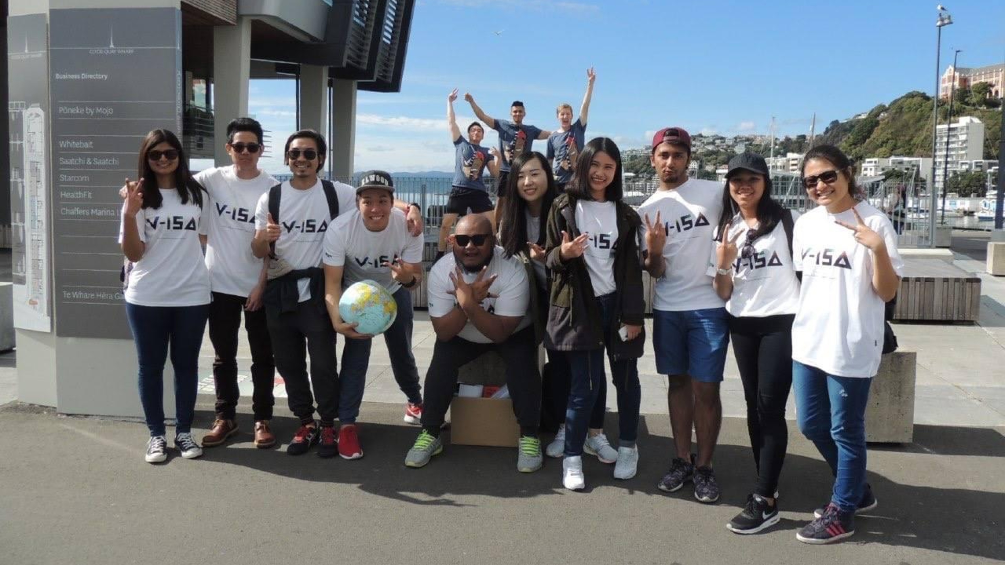 Students wearing white t-shorts with V-ISA logo, in Wellington harbour, during amazing race game.