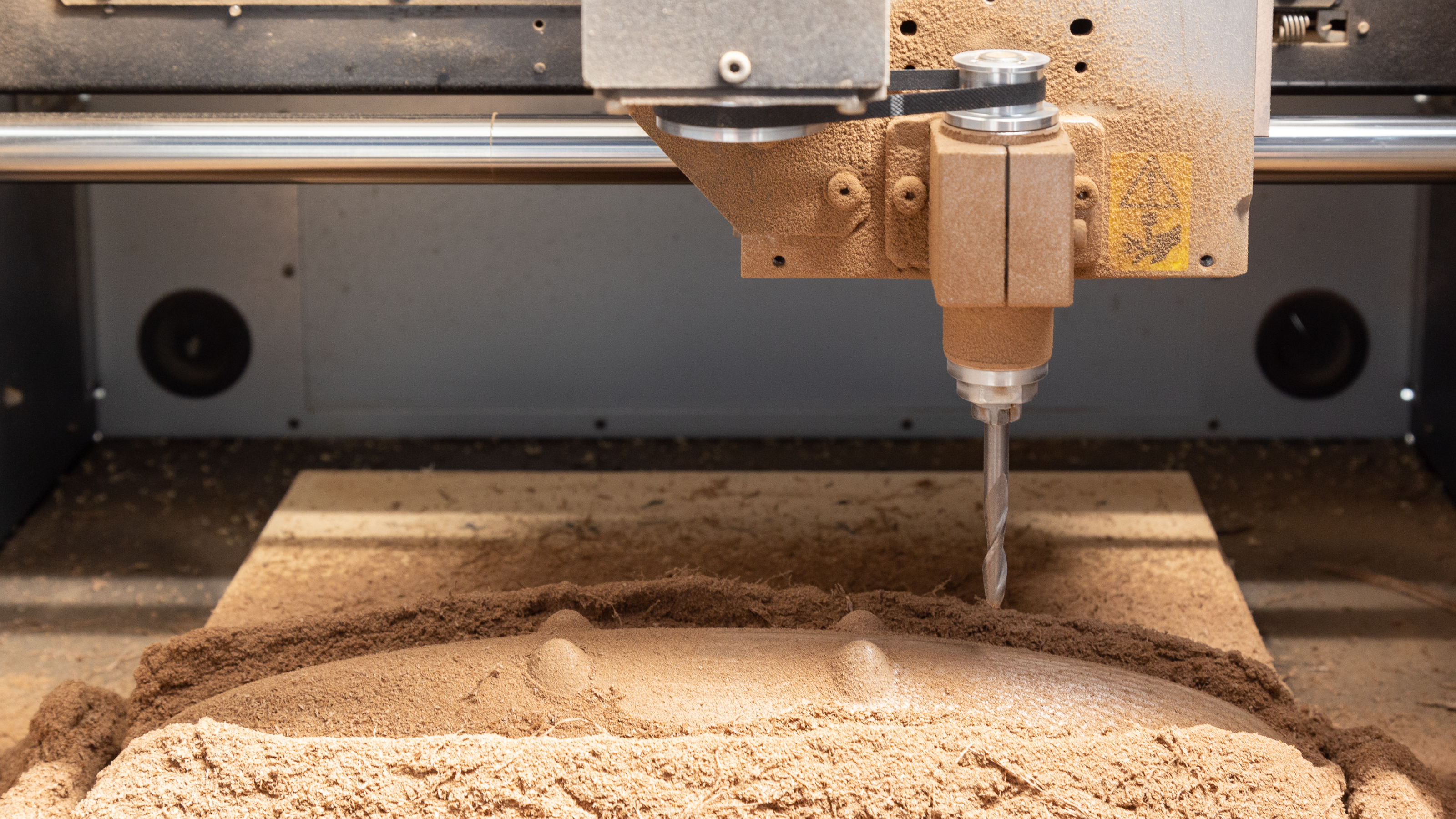 Close up of wood being cut with tabletop CNC machine