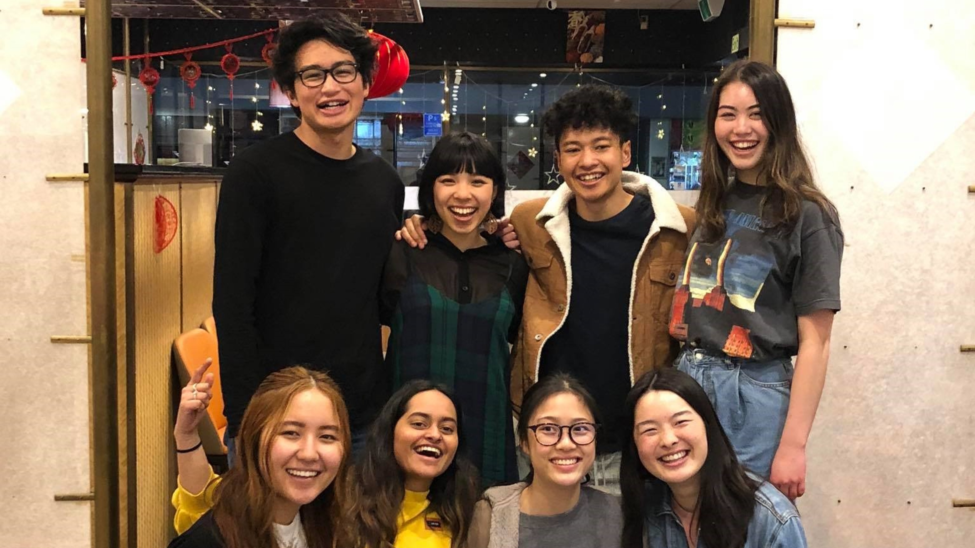 Group picture of students after one of their events, with decorations in the background.