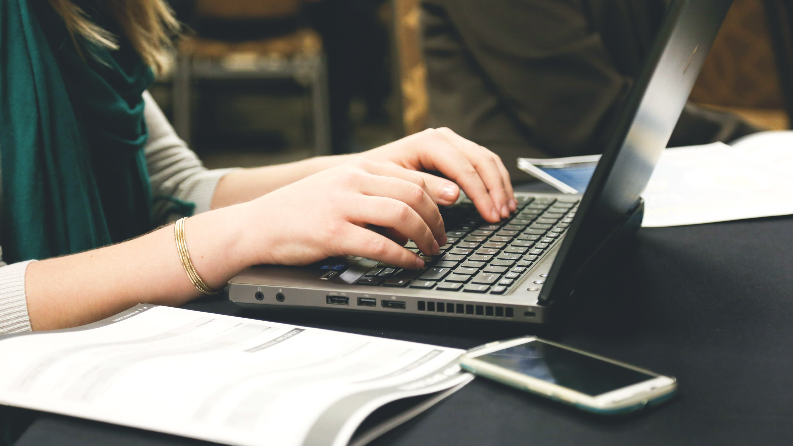 Close up of a woman typing on a laptop