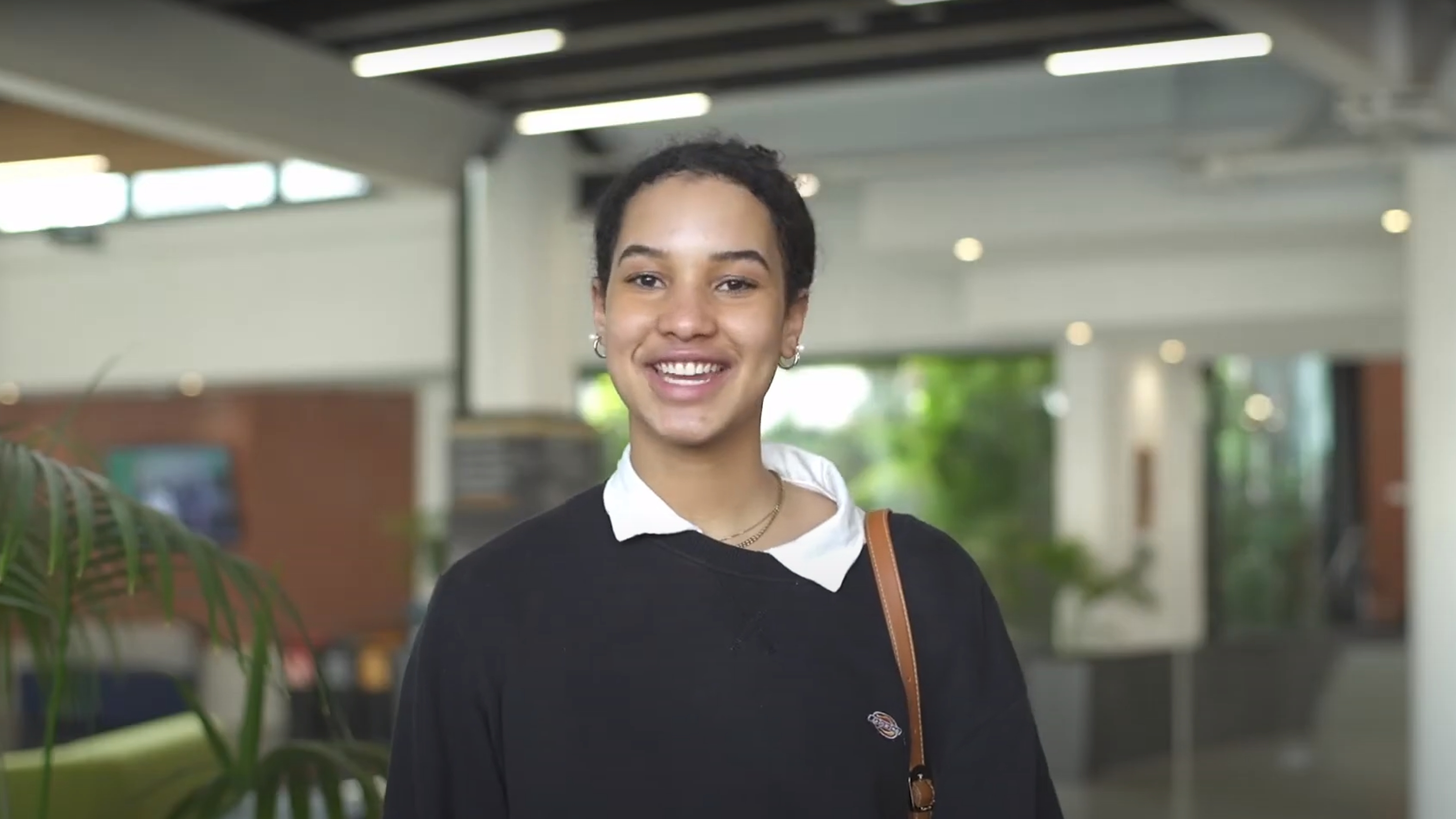 Student Aisha stands facing the camera