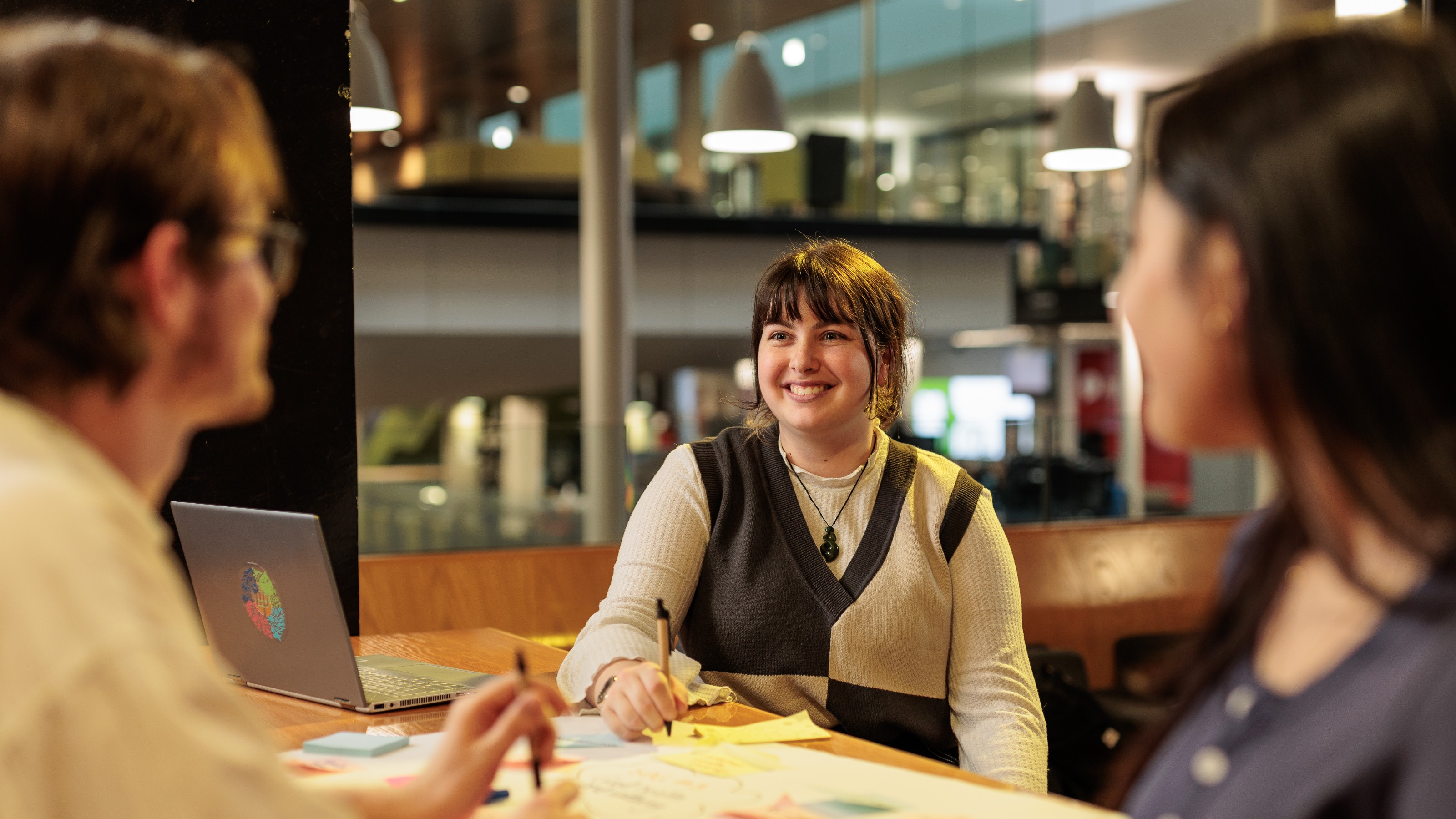 Three students studying at a table in The Hub.