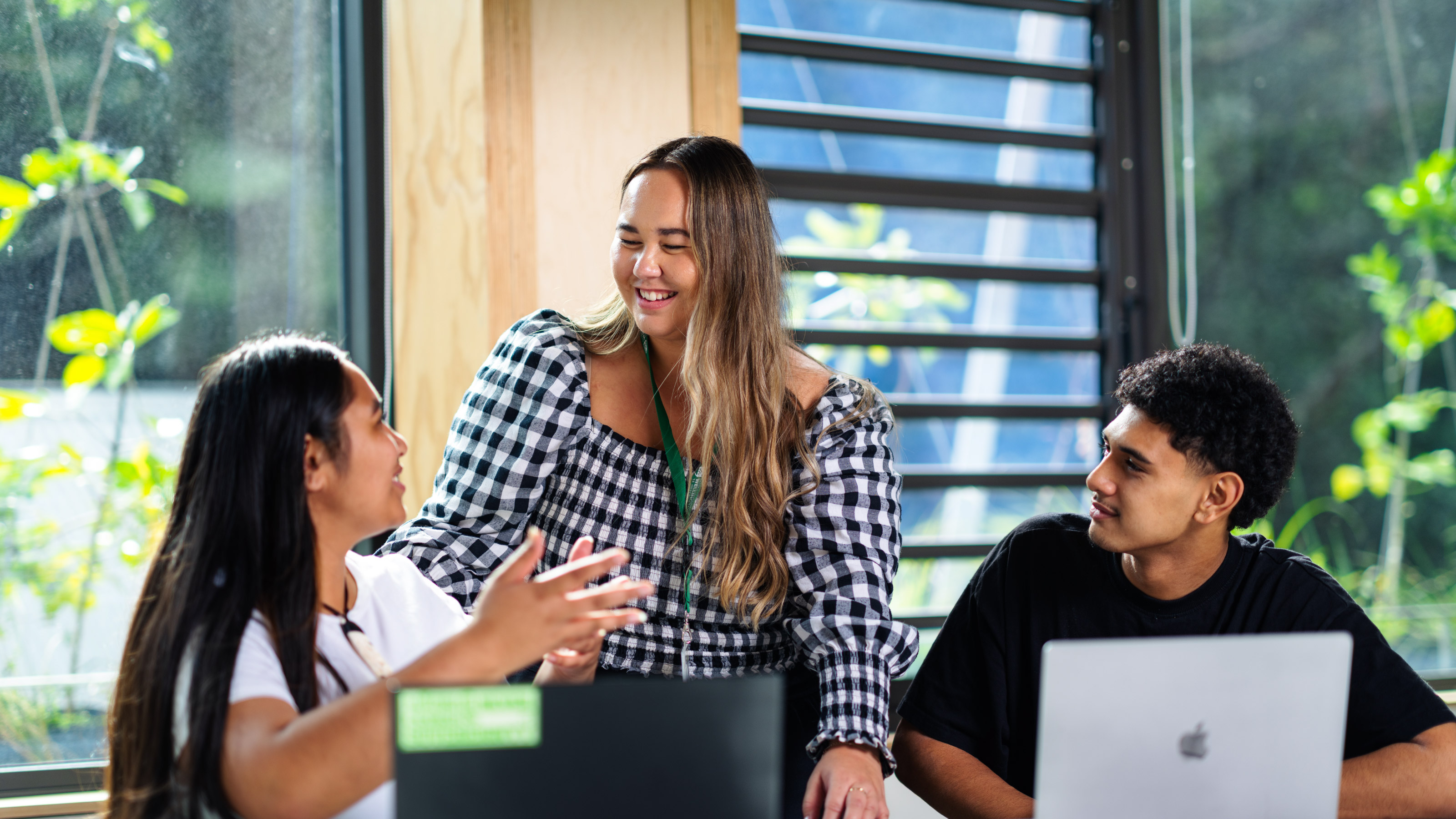 Staff member chatting and helping two students