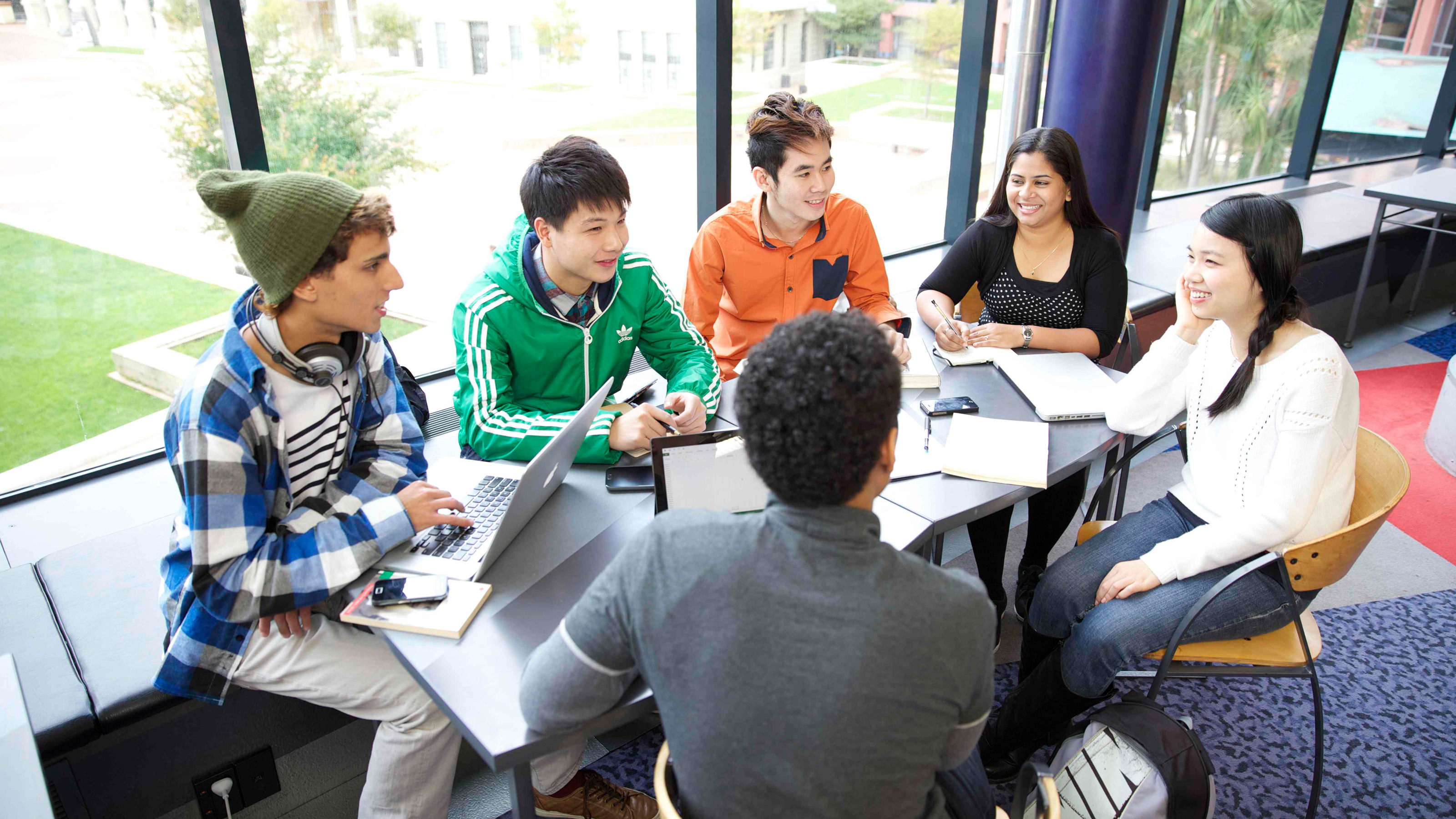 A group of students sitting around a table discussing a project