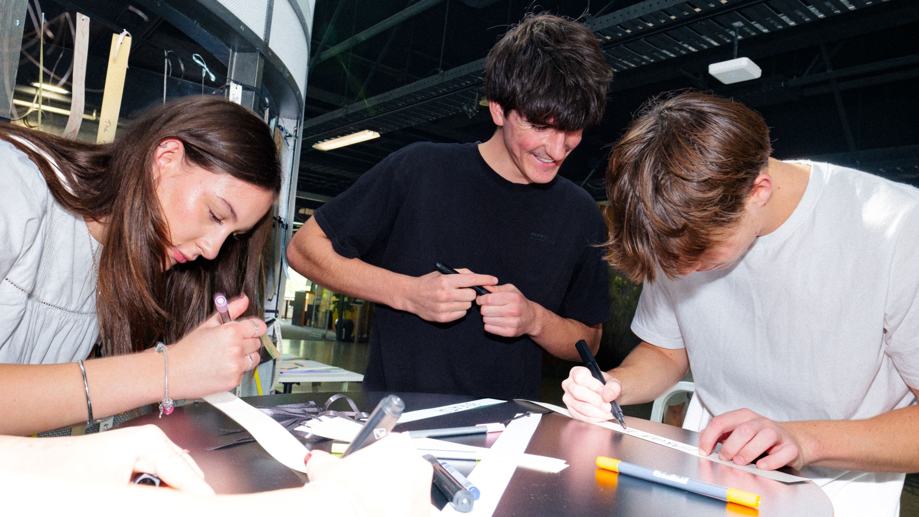 Three students working on physical paper