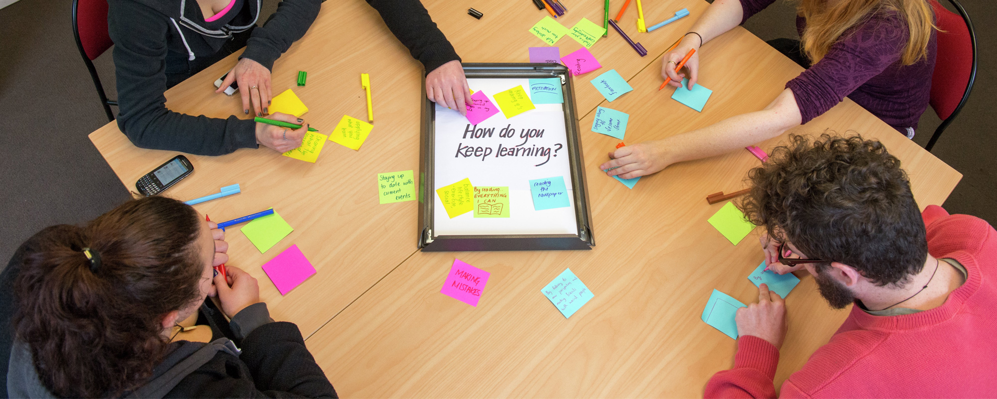 A group of students in a workshop looking at ideas around 'how to people keep learning'