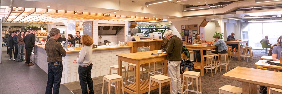 A line of students waiting at the counter of The Lab cafe, with University staff in the foreground
