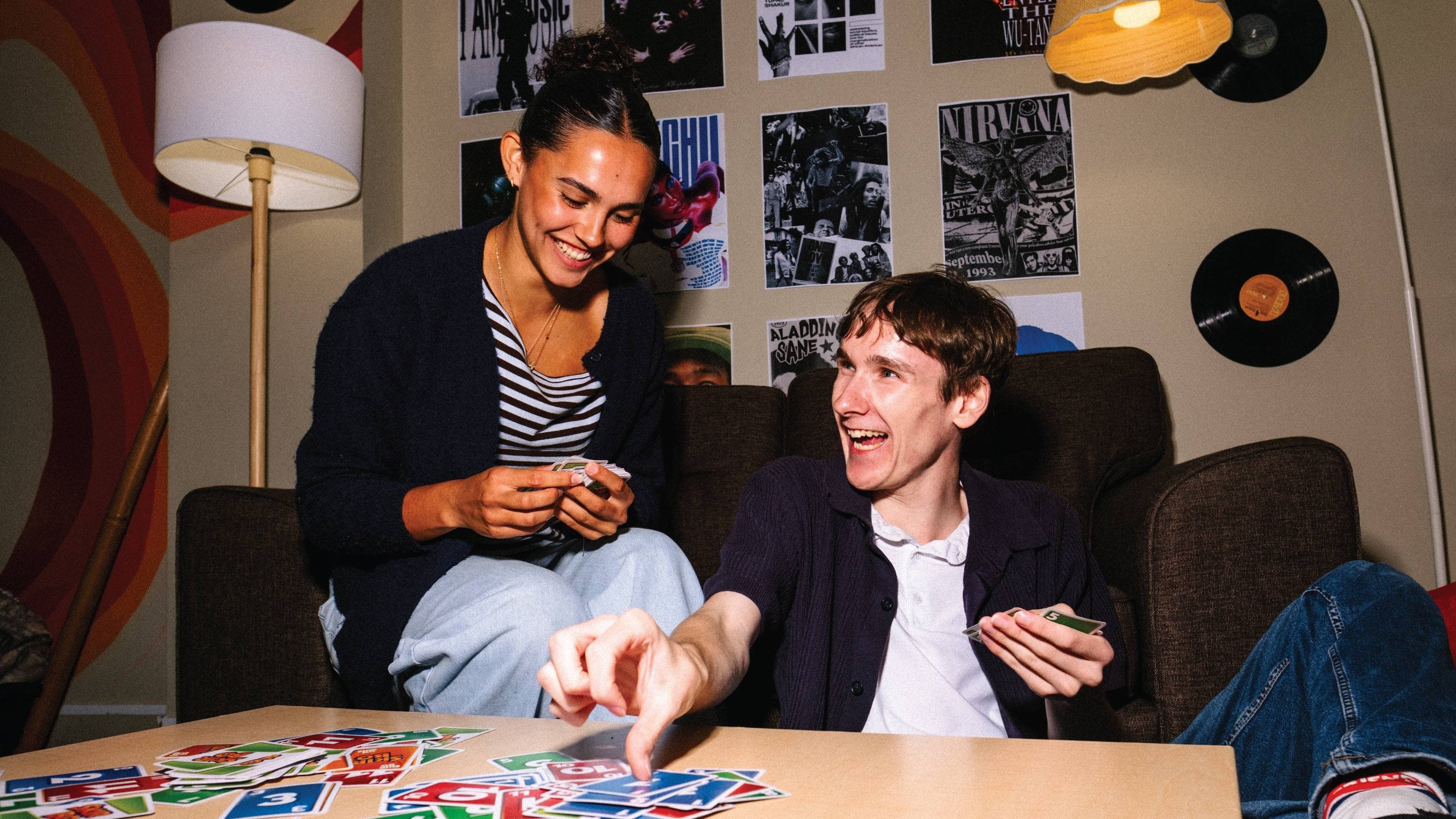 Two residents playing cards at their hall of residence