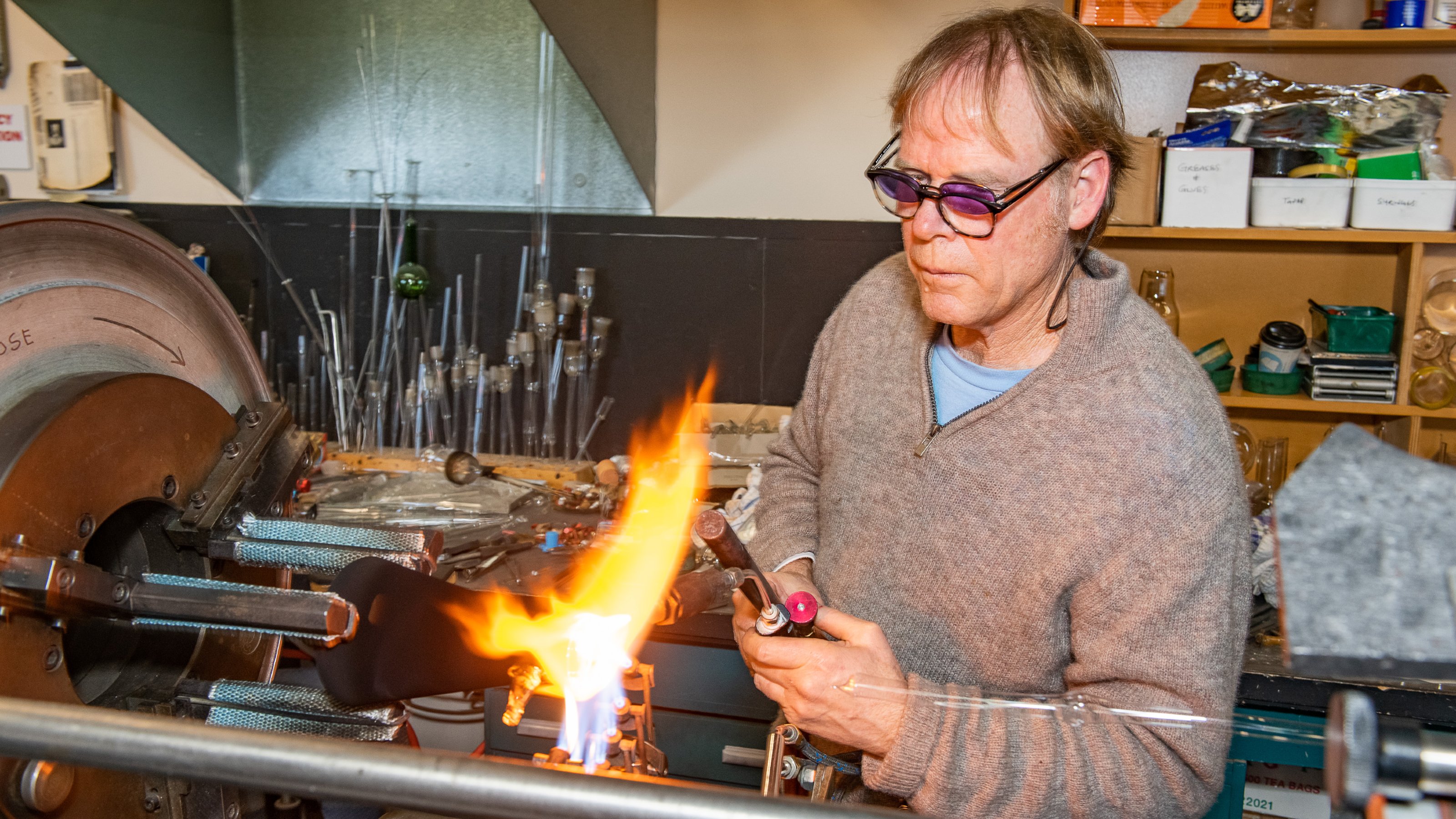 Man with blowtorch heating glass
