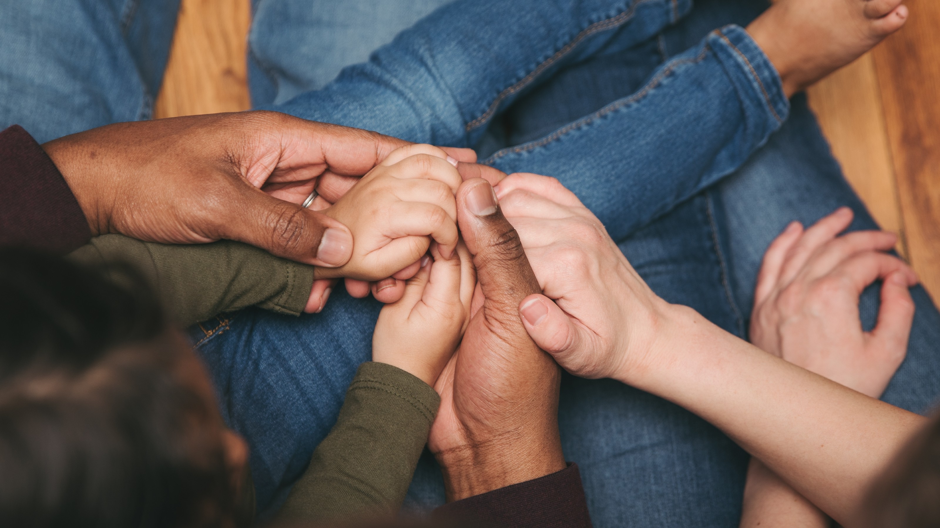 Two parents holding hands with a small child.