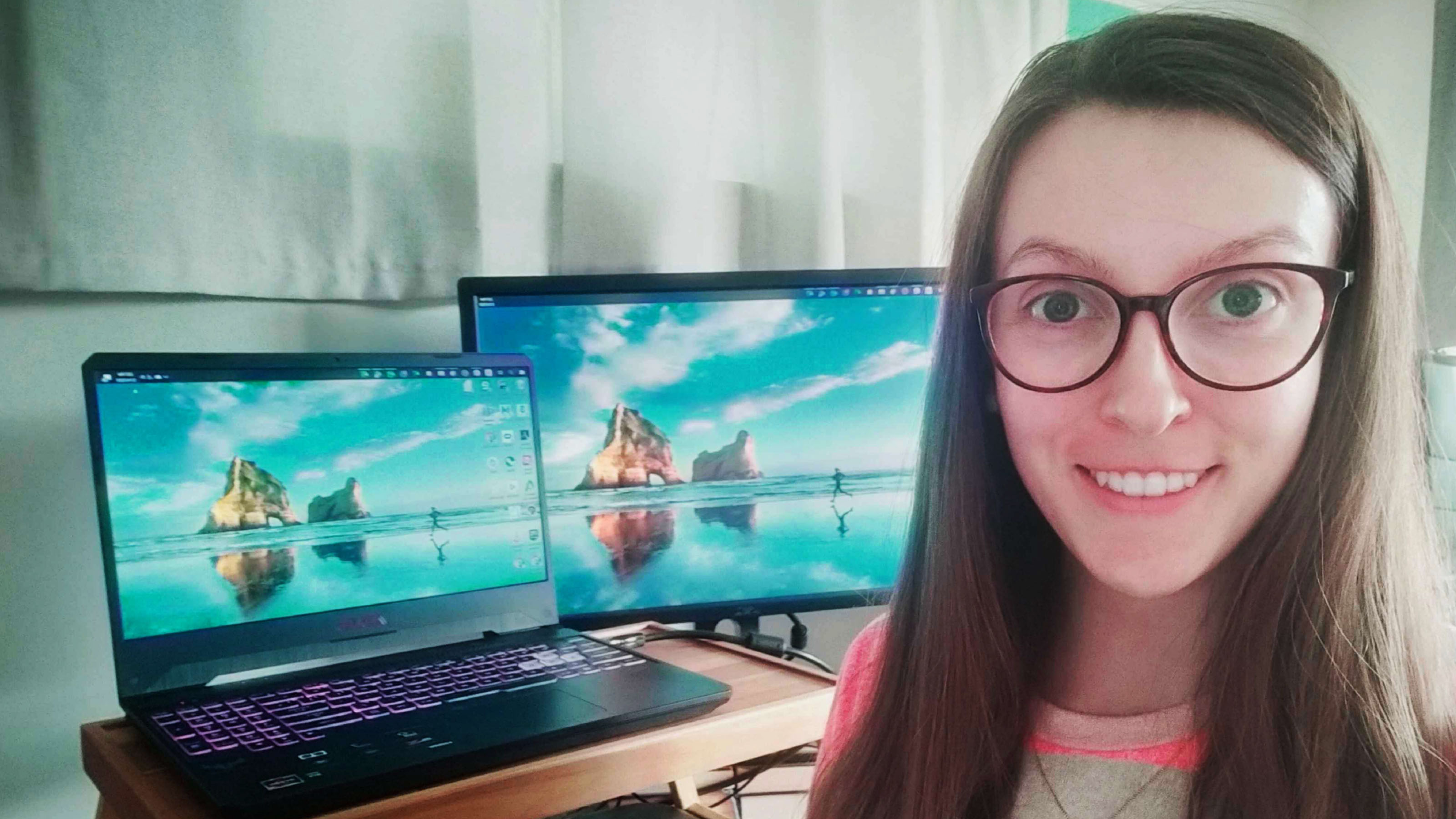 Chrissy MacDonald is staring at the camera with two laptops behind her on a desk.